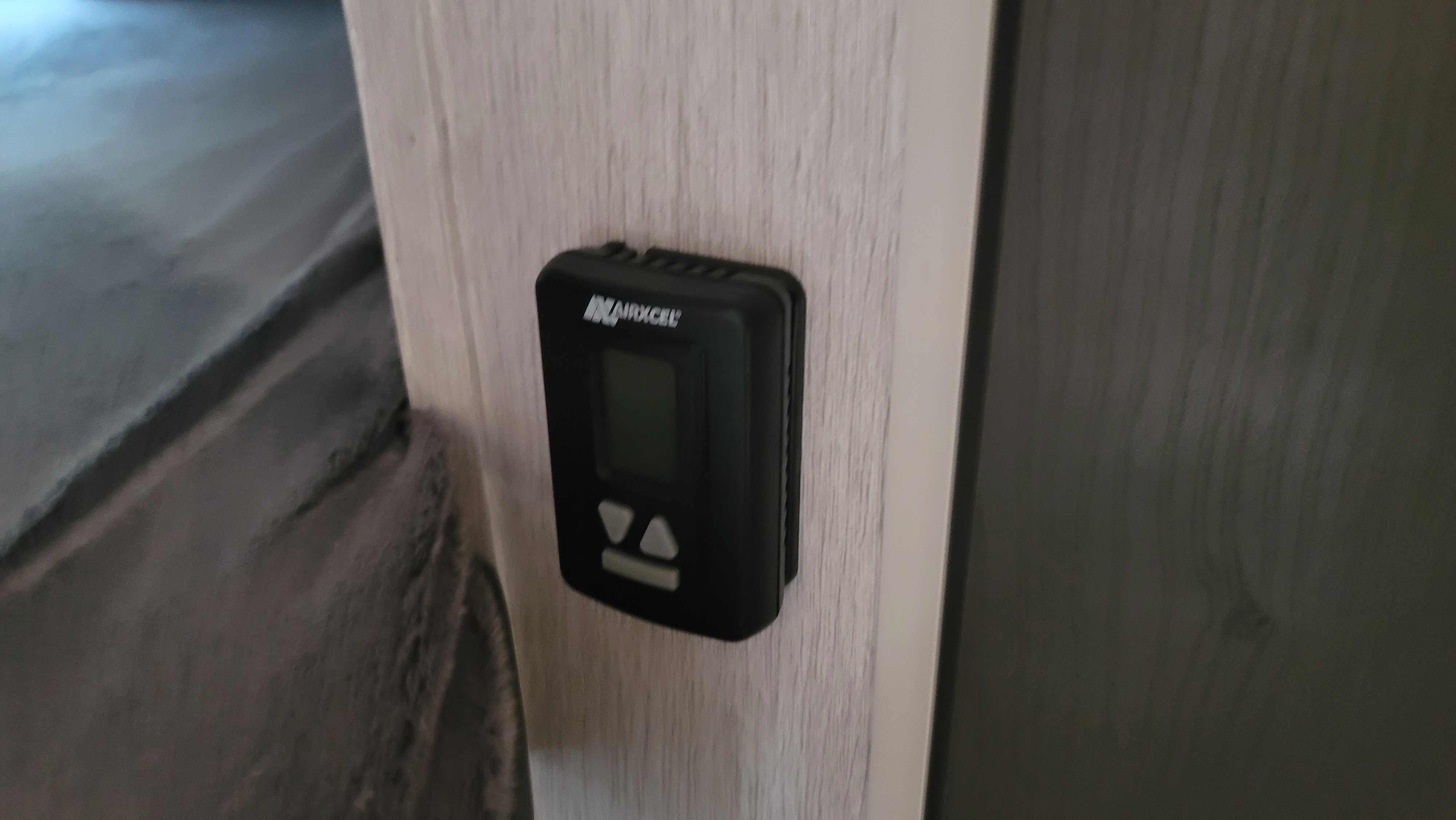 View of a digital AIRXCEL thermostat on a wall within an RV rental, next to a bed. Controls climate settings.. Forest River Forest River EVO 2023
