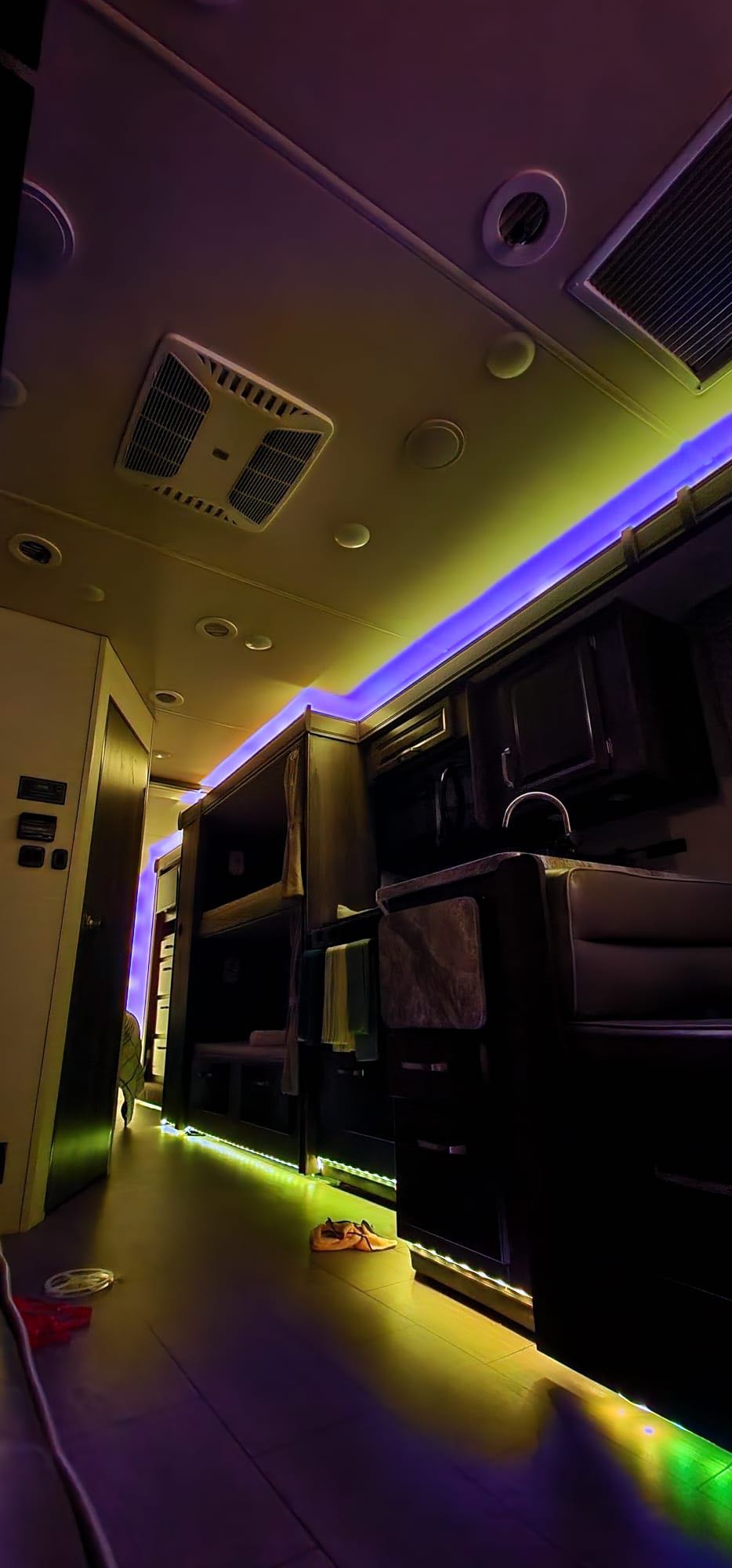 Explore this modern RV rental interior, lit by vibrant LED lights. Features bunk beds, a compact kitchen, and a cozy atmosphere.. Jayco Greyhawk 2019