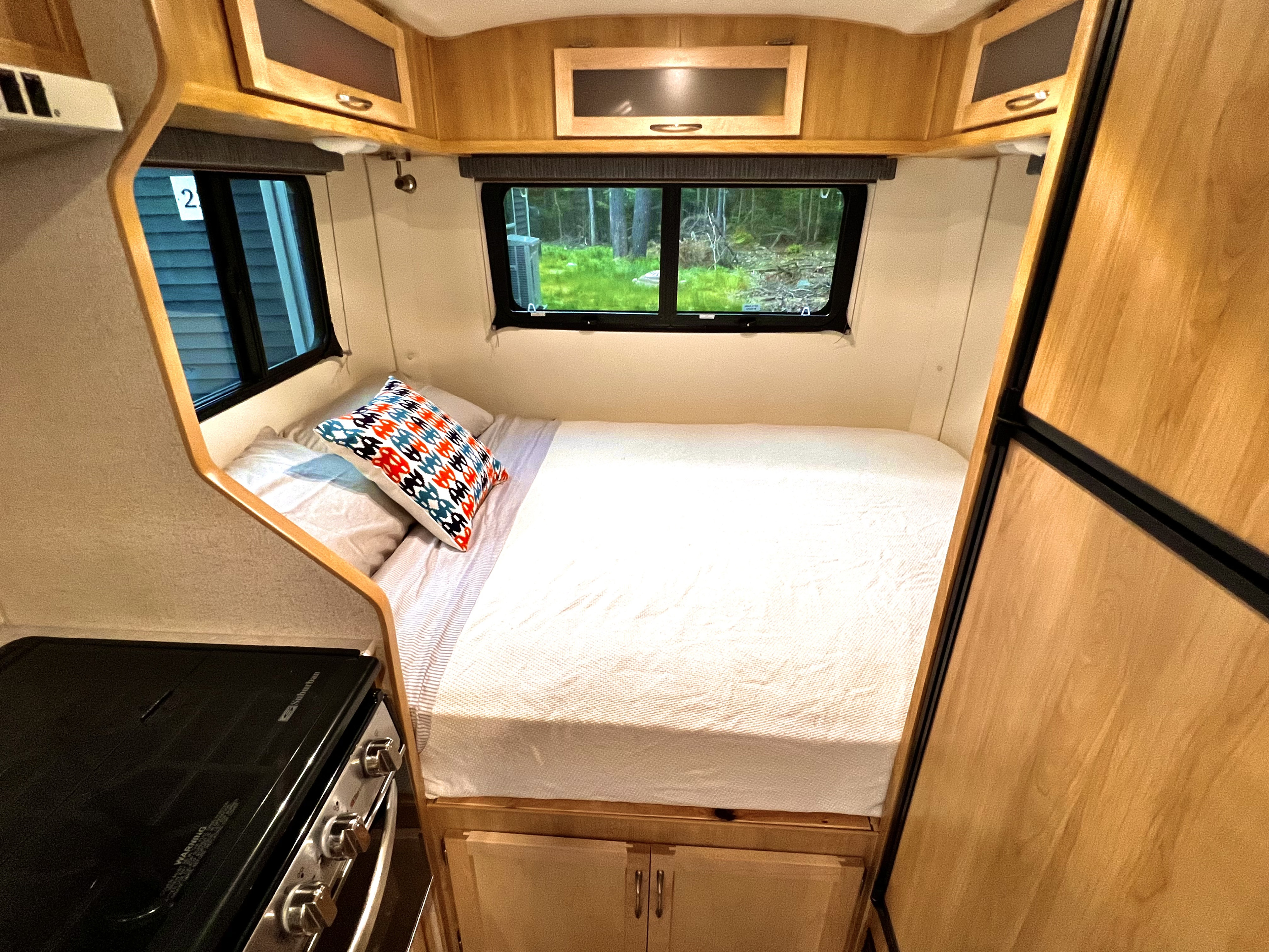 This RV rental showcases a compact interior with a comfortable bed, overhead storage, and a kitchenette, offering scenic views.. Escape Trailer Escape Trailer Trailer 2022