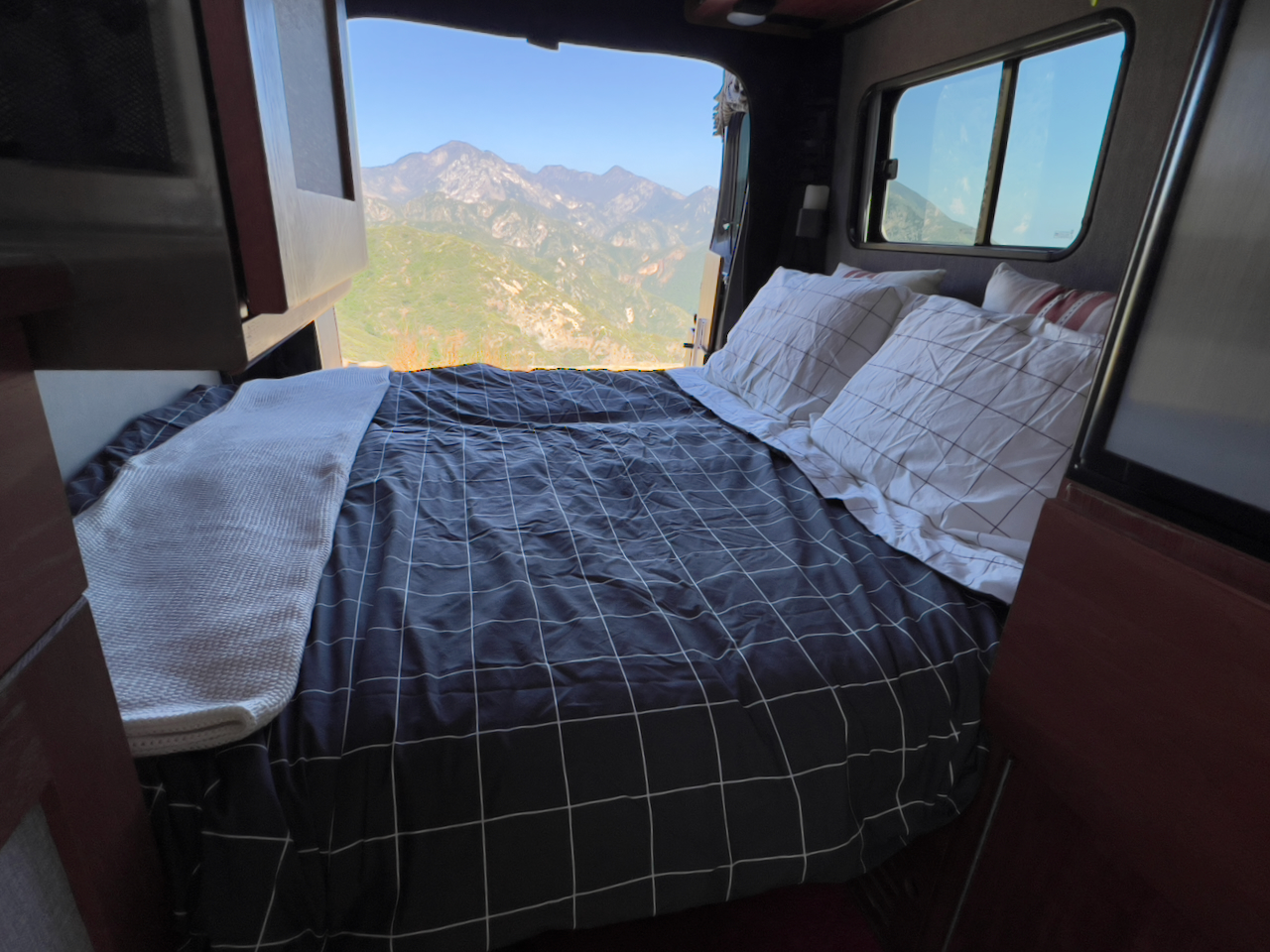 Relax in this RV rental bed with a striking mountain view from your mobile home. Perfect for scenic travels.. Roadtrek Simplicity SRT 2019