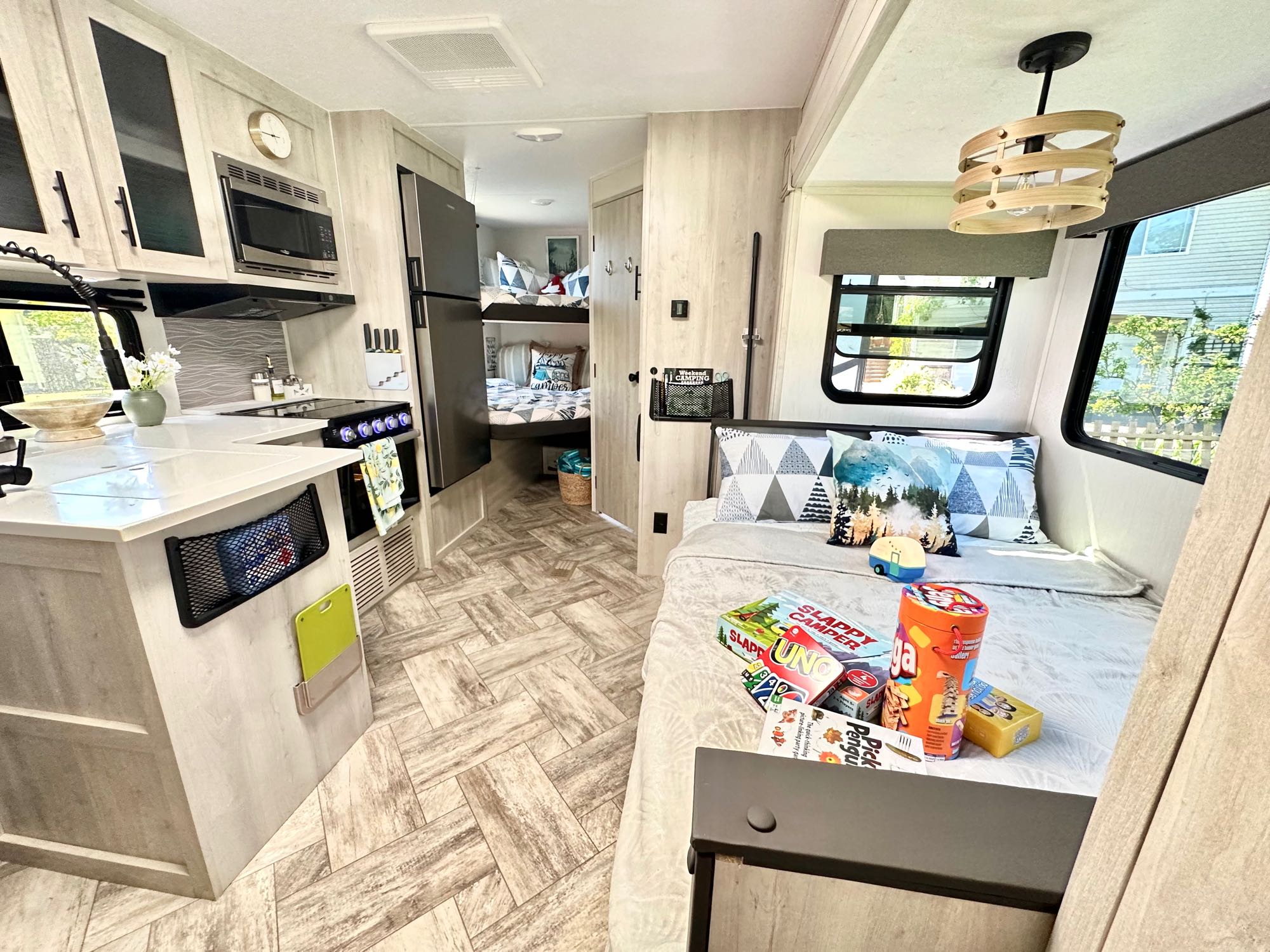 Experience comfort in this modern RV rental! The spacious interior features a full kitchen, main bed, and cozy bunk beds.. Forest River Wildcat 2023