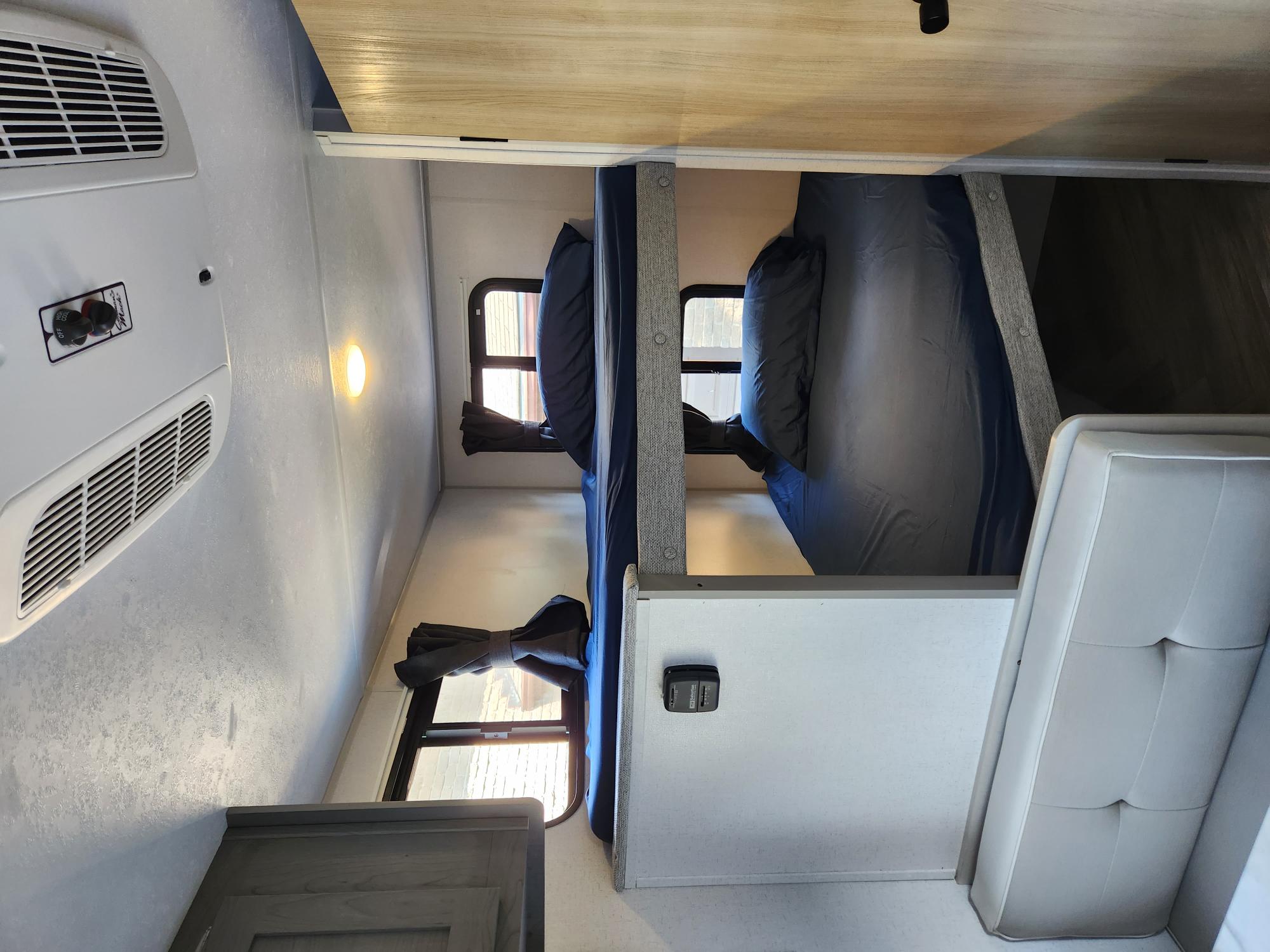 RV rental bunk beds, offering a compact sleeping area with AC and windows for travelers.. Ozark Ozark Trailer 2023