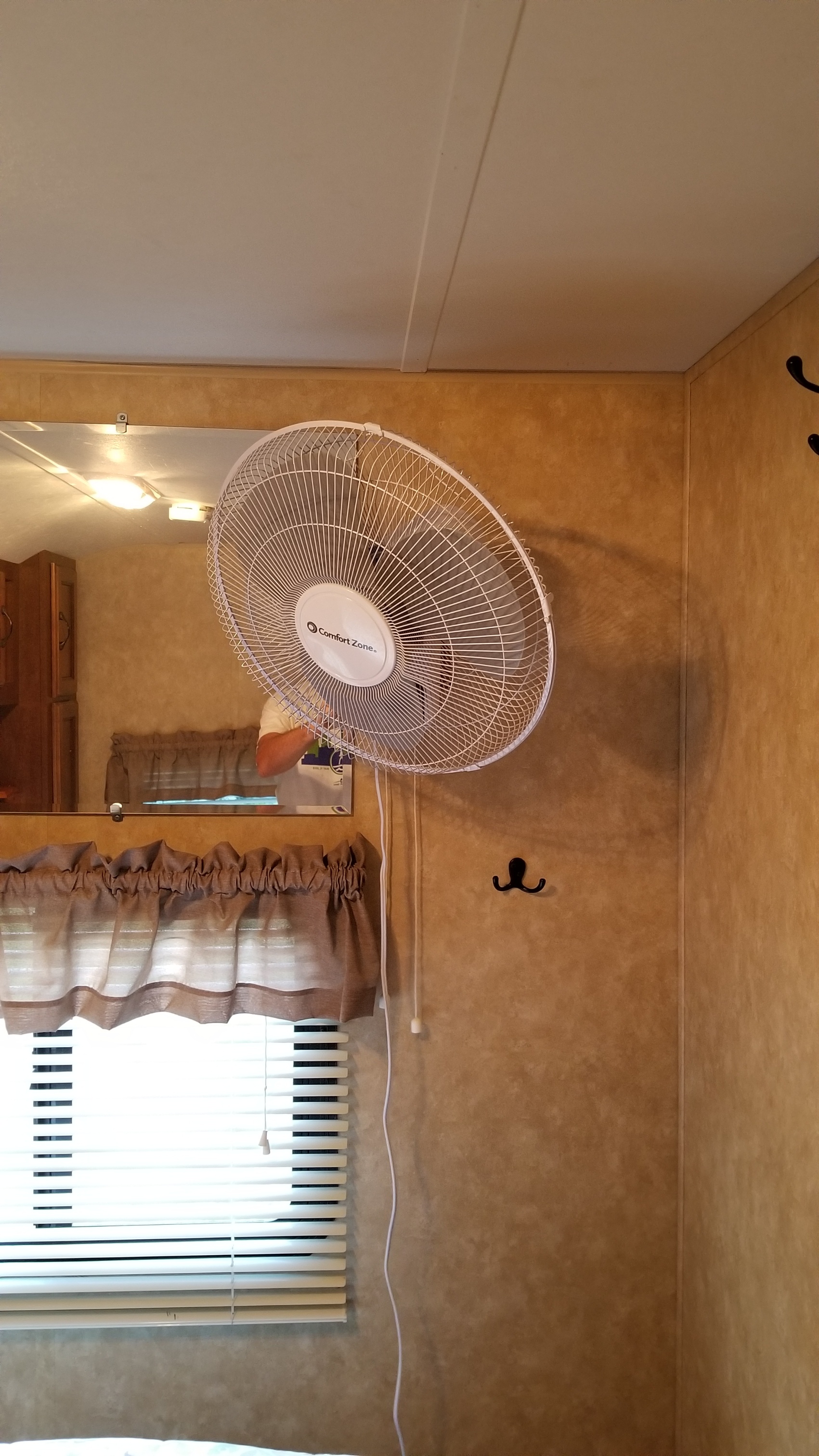 RV rental interior featuring a wall-mounted fan, mirror, and window with blinds, creating a comfortable travel space.. Forest River Coachmen Catalina 2013