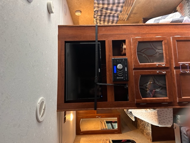 RV rental living space: Featuring a flat-screen TV, stereo, and elegant wood cabinetry, providing comfort and entertainment inside.. Forest River Tracer Ultra Lite Executive 2014