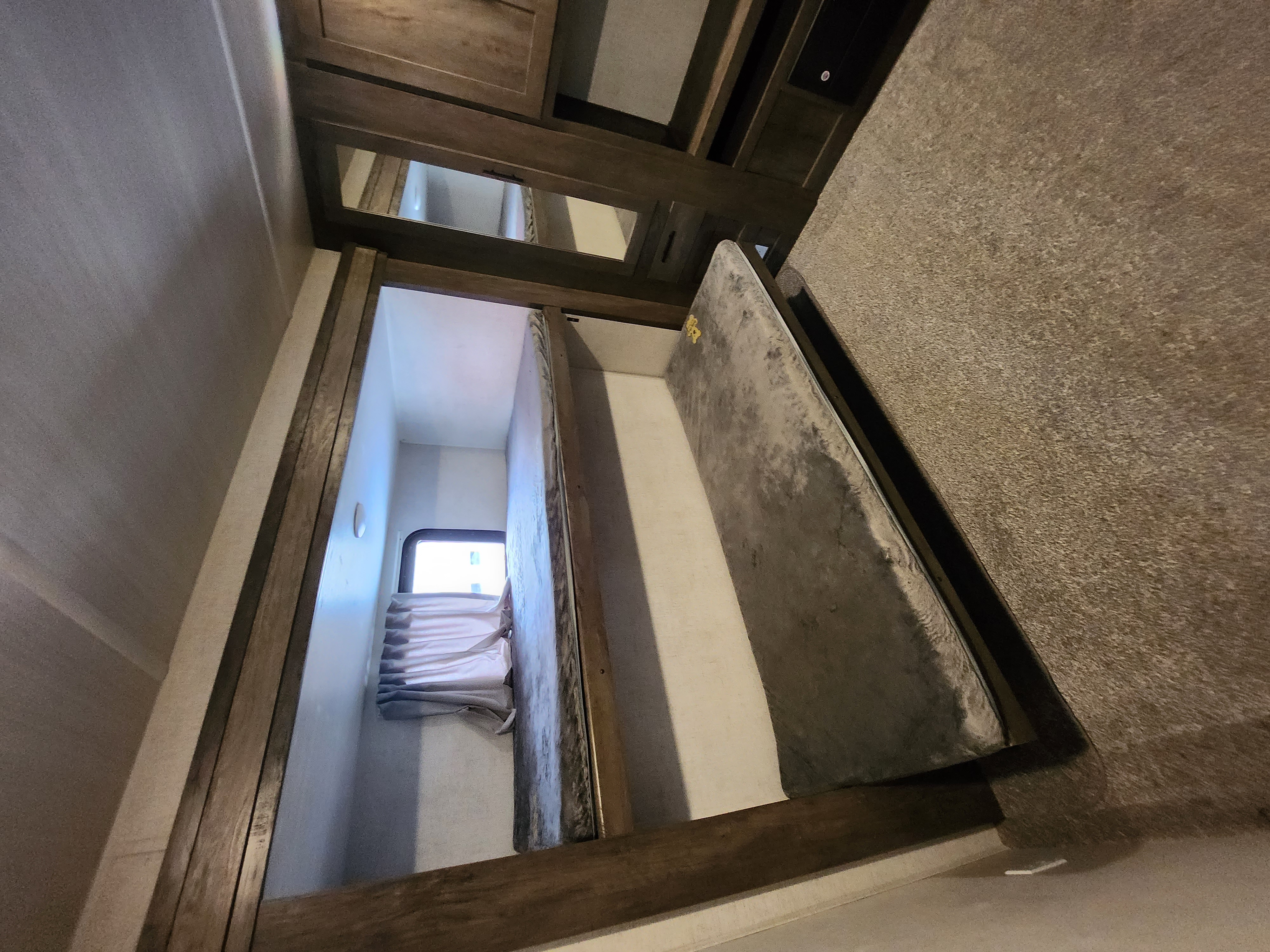 Cozy RV rental bunk beds with a window and wooden details, offering compact sleeping quarters for your travels.. Forest River Salem 2020