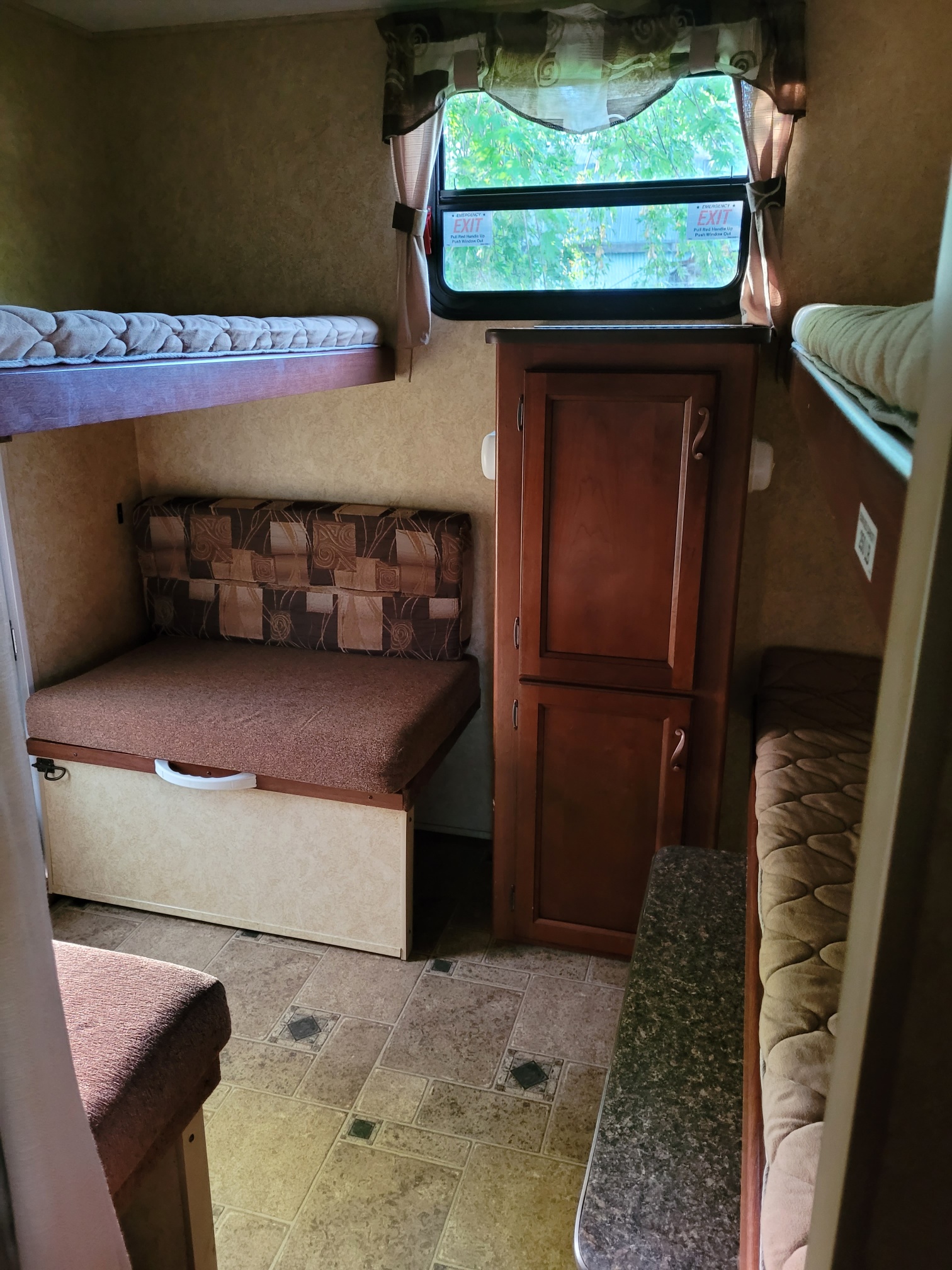 Explore this RV rental interior: bunk beds, convertible dinette, cabinet, and emergency exit window for safe travels.. Forest River Lacrosse 2011