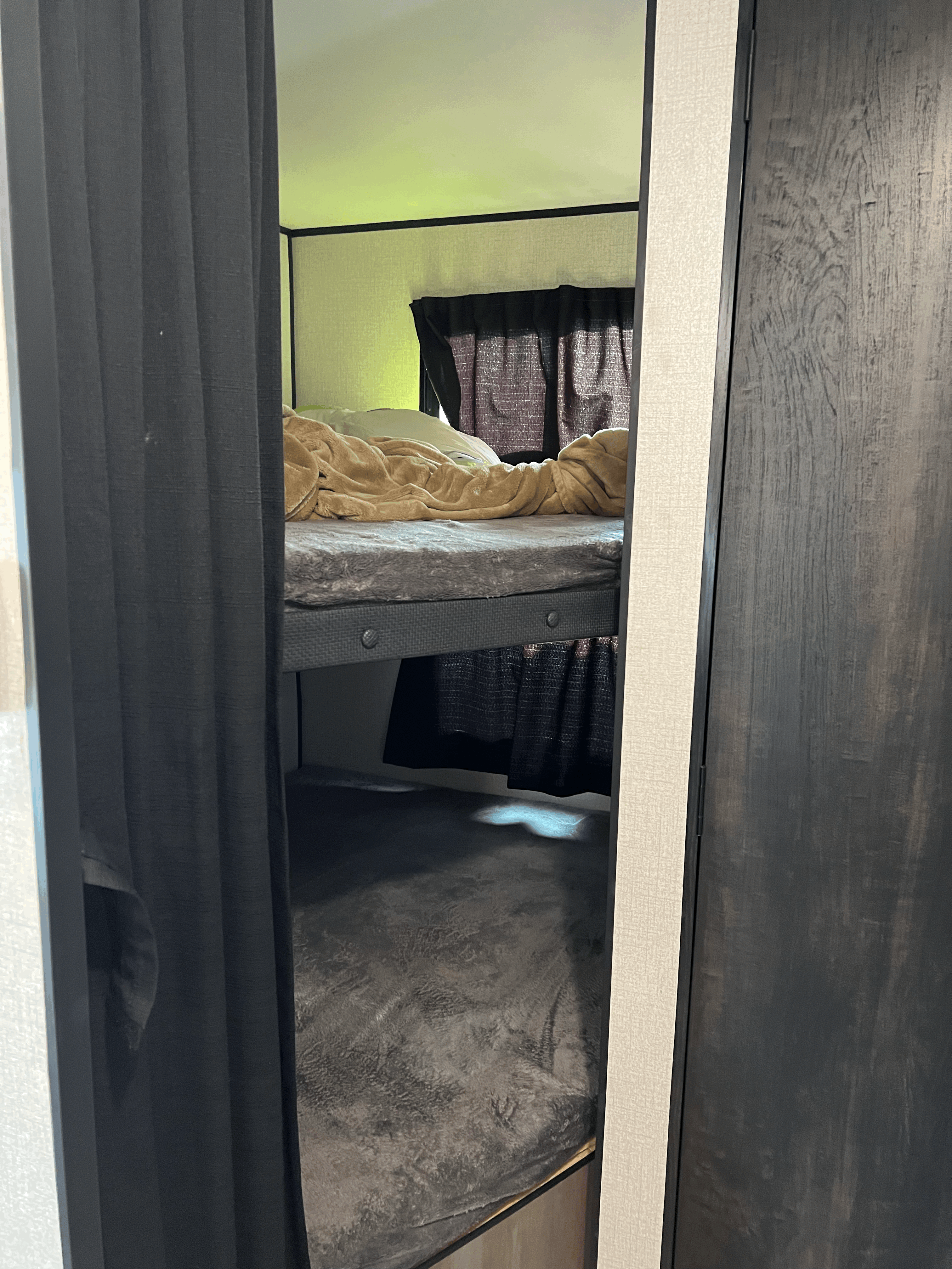 View of the bunk bed sleeping area within an RV rental, complete with bedding and privacy curtains.. Highland Ridge RV Open Range 2022