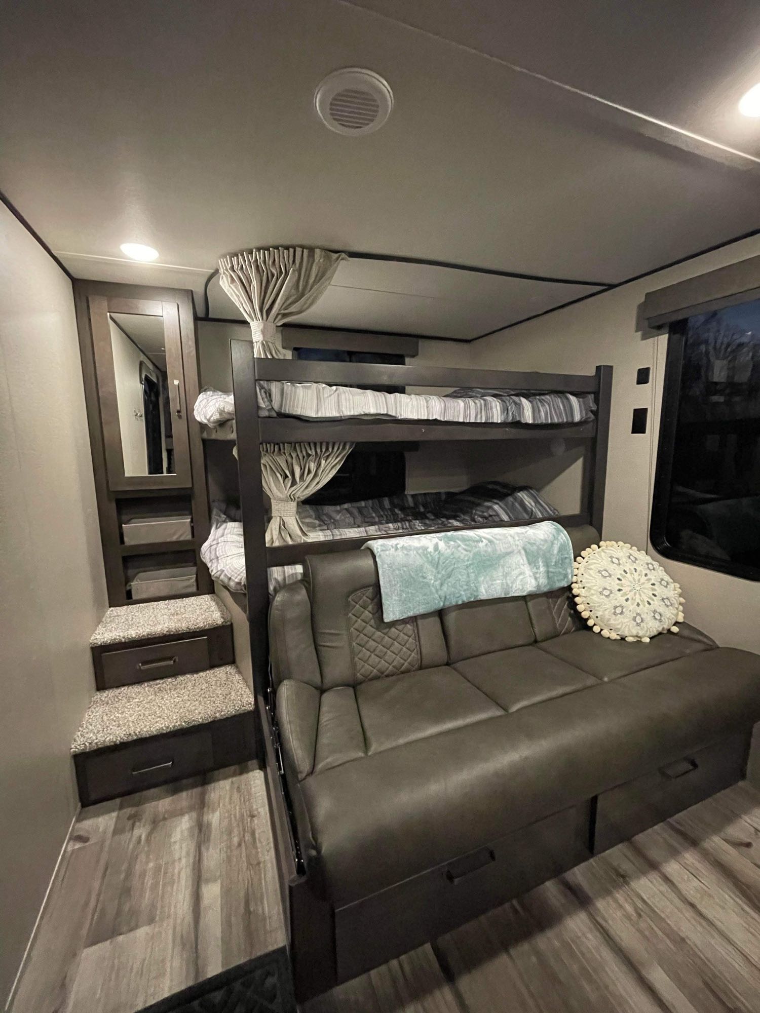 This RV rental interior features comfortable bunk beds, a sofa, and smart storage, perfect for family travel.. Grand Design Transcend Xplor 2023