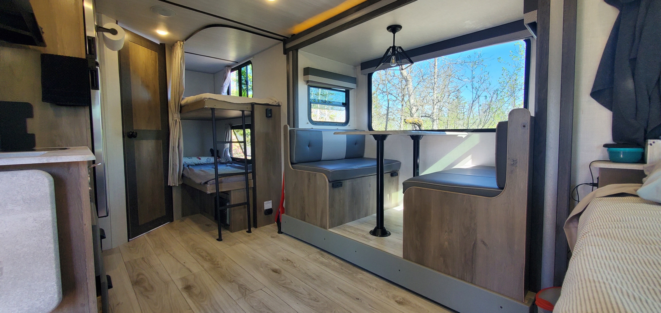 This RV rental features a modern interior with two bunk beds and a large dinette with scenic views.. Forest River Surveyor Legend 2022