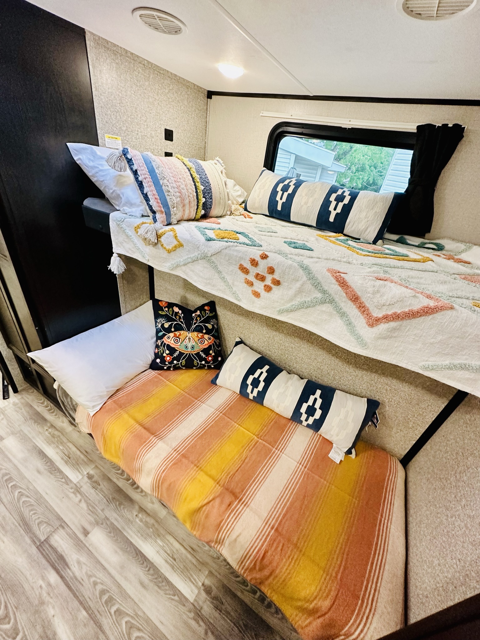Cozy RV rental bunk beds, perfect for family travel, with colorful textiles and a window view.. Highland Ridge RV Mesa Ridge 2022
