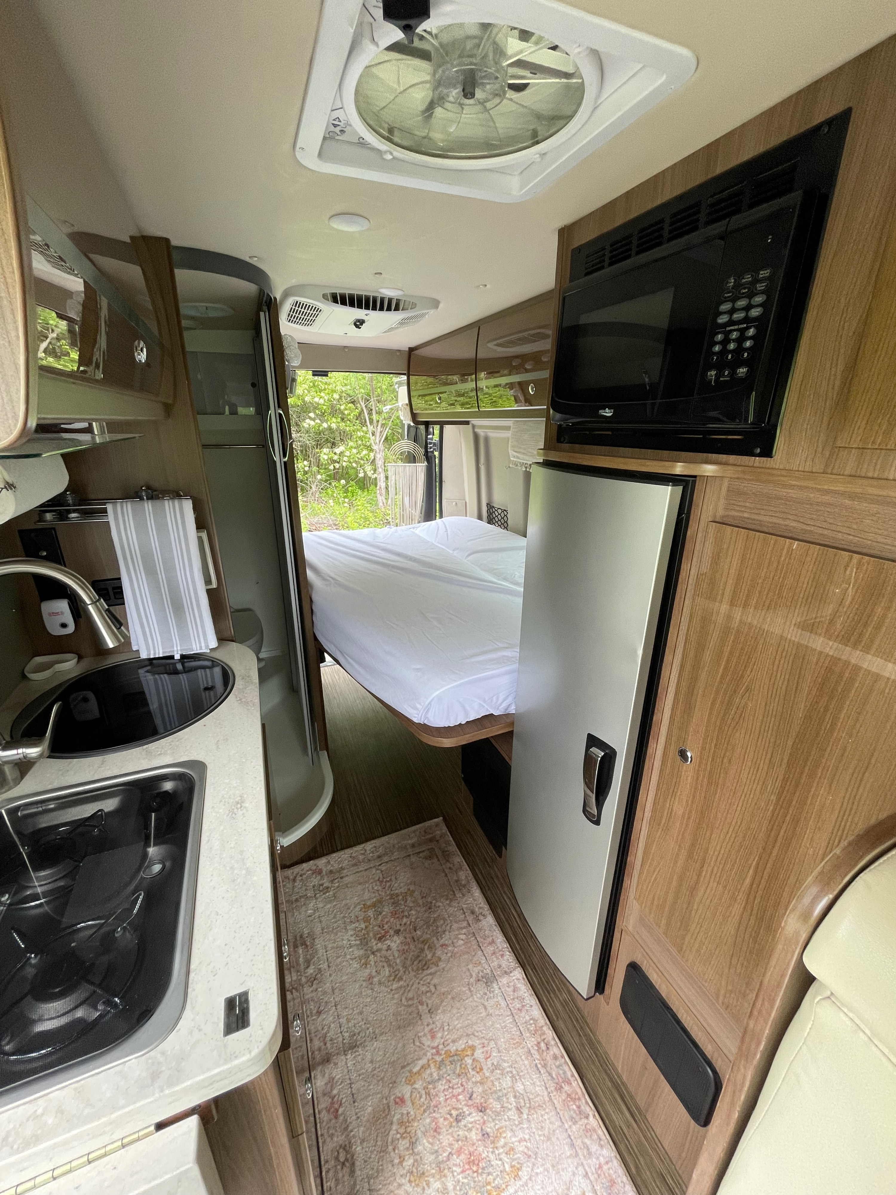 RV rental interior: kitchen (sink, stove), compact bath, comfy bed, microwave, fridge. Ready for travel!. Winnebago Travato 2017