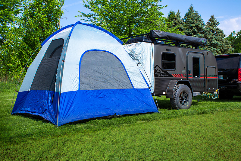 Large blue tent attached to a compact gray 'Flyer' travel trailer, ideal for an RV rental adventure in nature.. InTech RV InTech RV Trailer 2020
