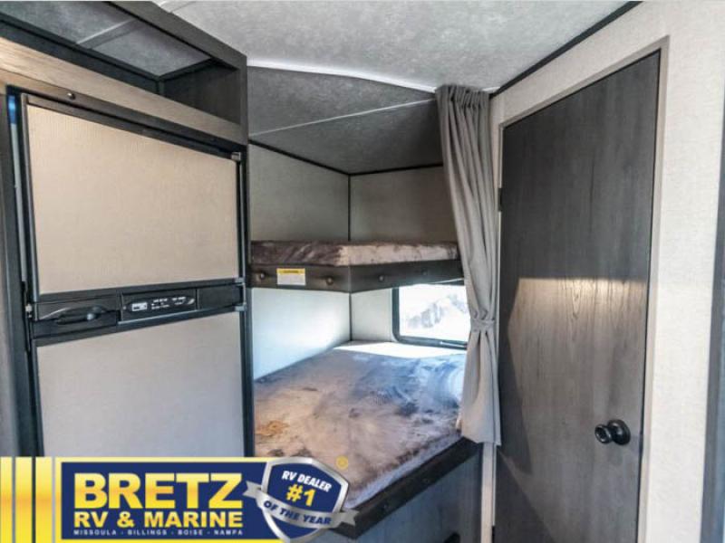 RV rental interior showcasing compact kitchen area with refrigerator, and cozy bunk beds. Perfect for family adventures.. Dutchmen Aspen Trail 2340BHSWE 2022