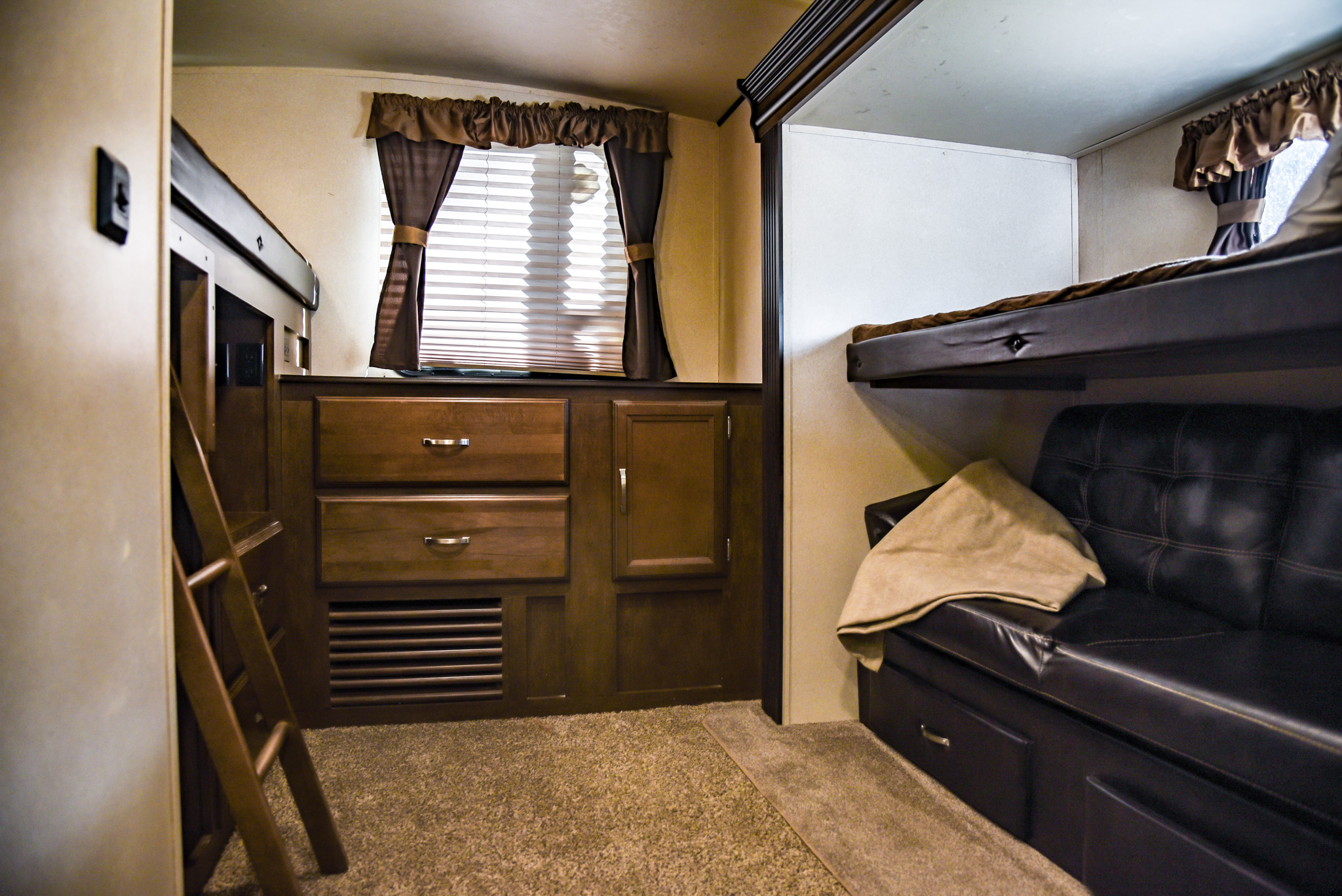 Spacious RV rental bunkhouse features bunk beds, a convertible sofa, wooden storage, and a window for comfortable travel.. Forest River Wildwood Heritage Glen Lite 2018