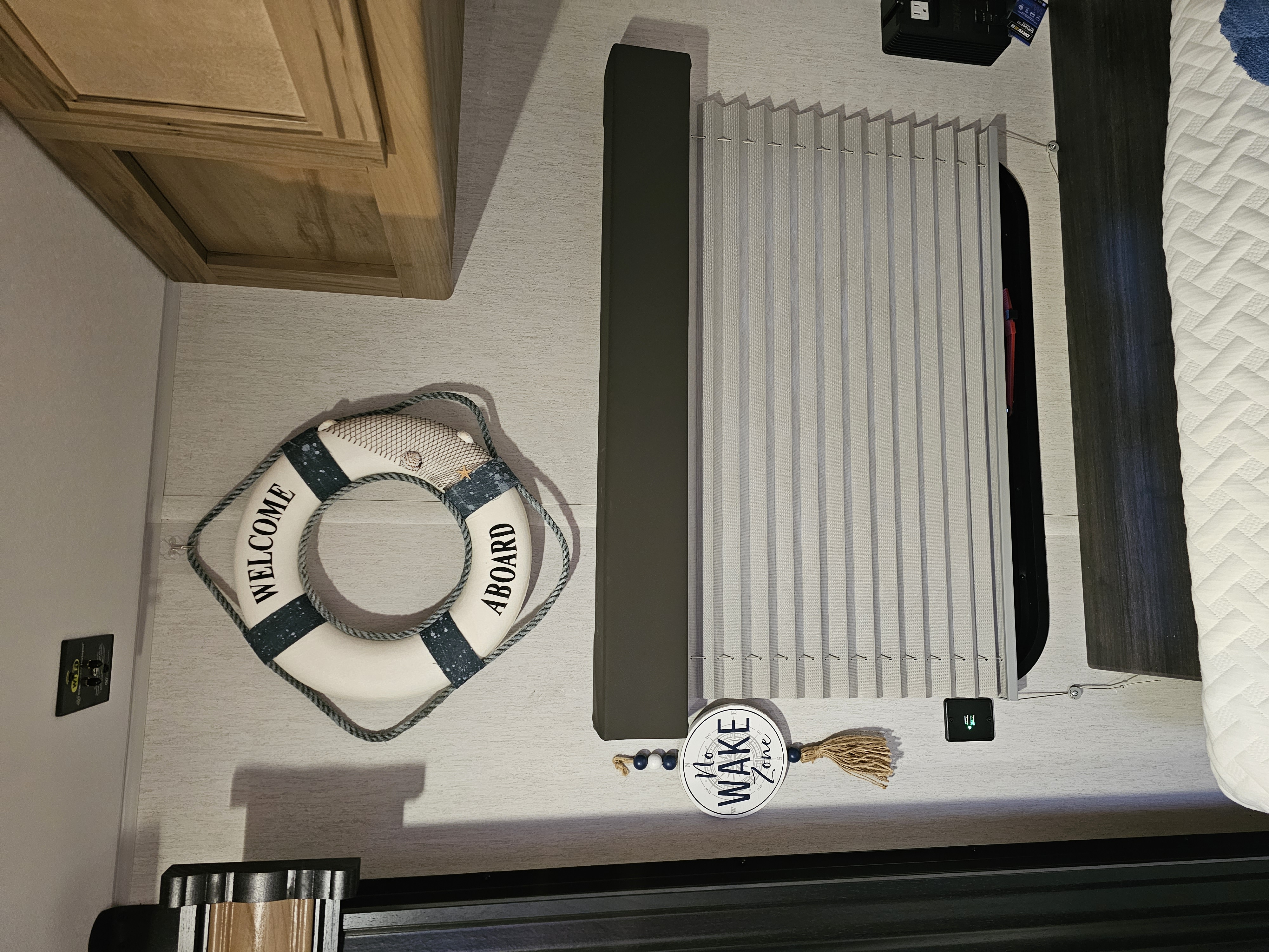 Explore this cozy RV rental interior: bedroom features nautical decor, vertical window blinds, and practical wooden cabinetry.. Forest River Wolf pup 17JW 2023