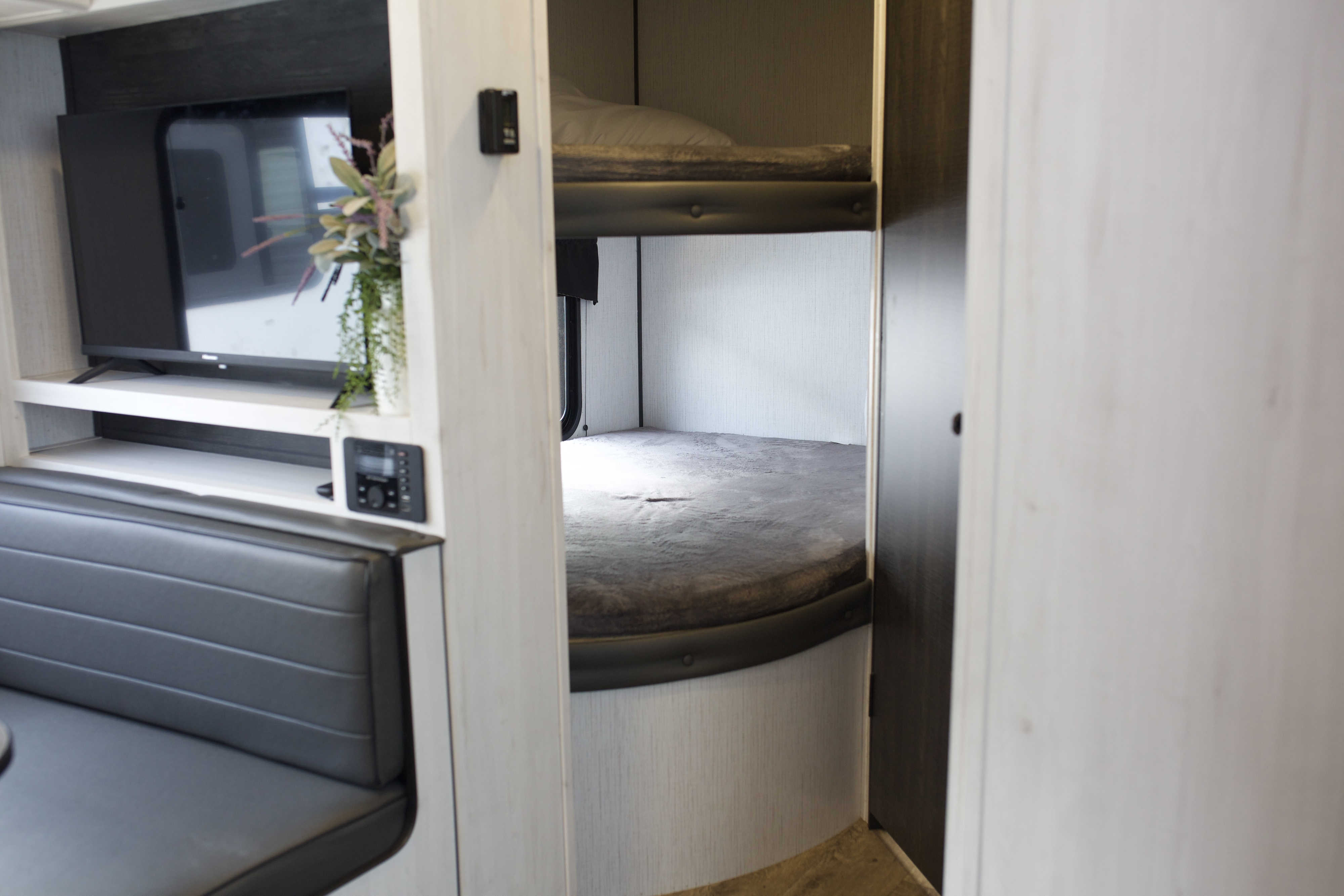RV rental interior: living area with TV, upholstered dinette, and dedicated bunk beds visible.. Heartland Trail Runner 2022