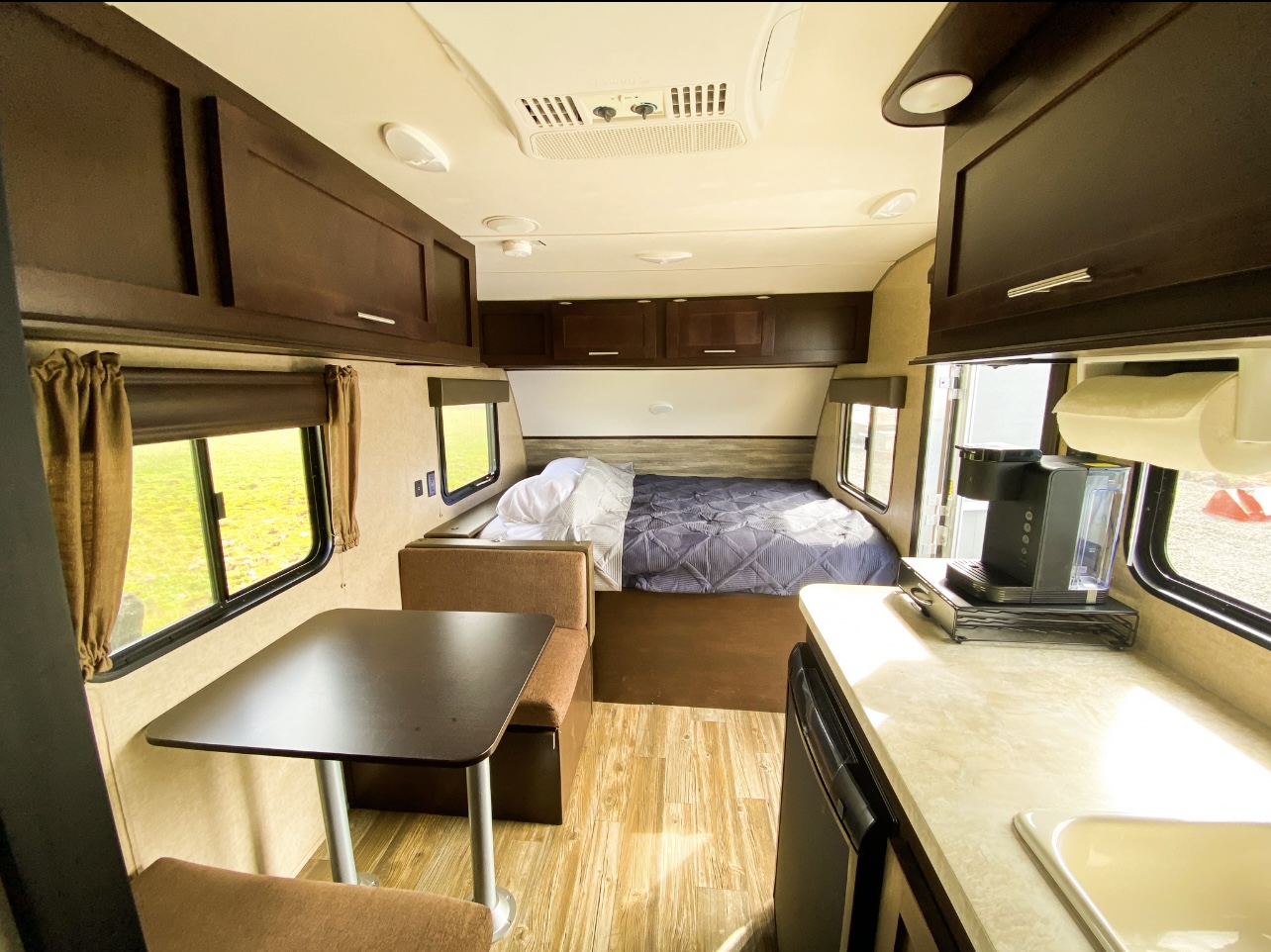 Cozy RV rental interior: features a comfy bed, dining nook, and practical kitchenette. Ideal for road trips!. Cherokee Wolf Cherokee Wolf 2018