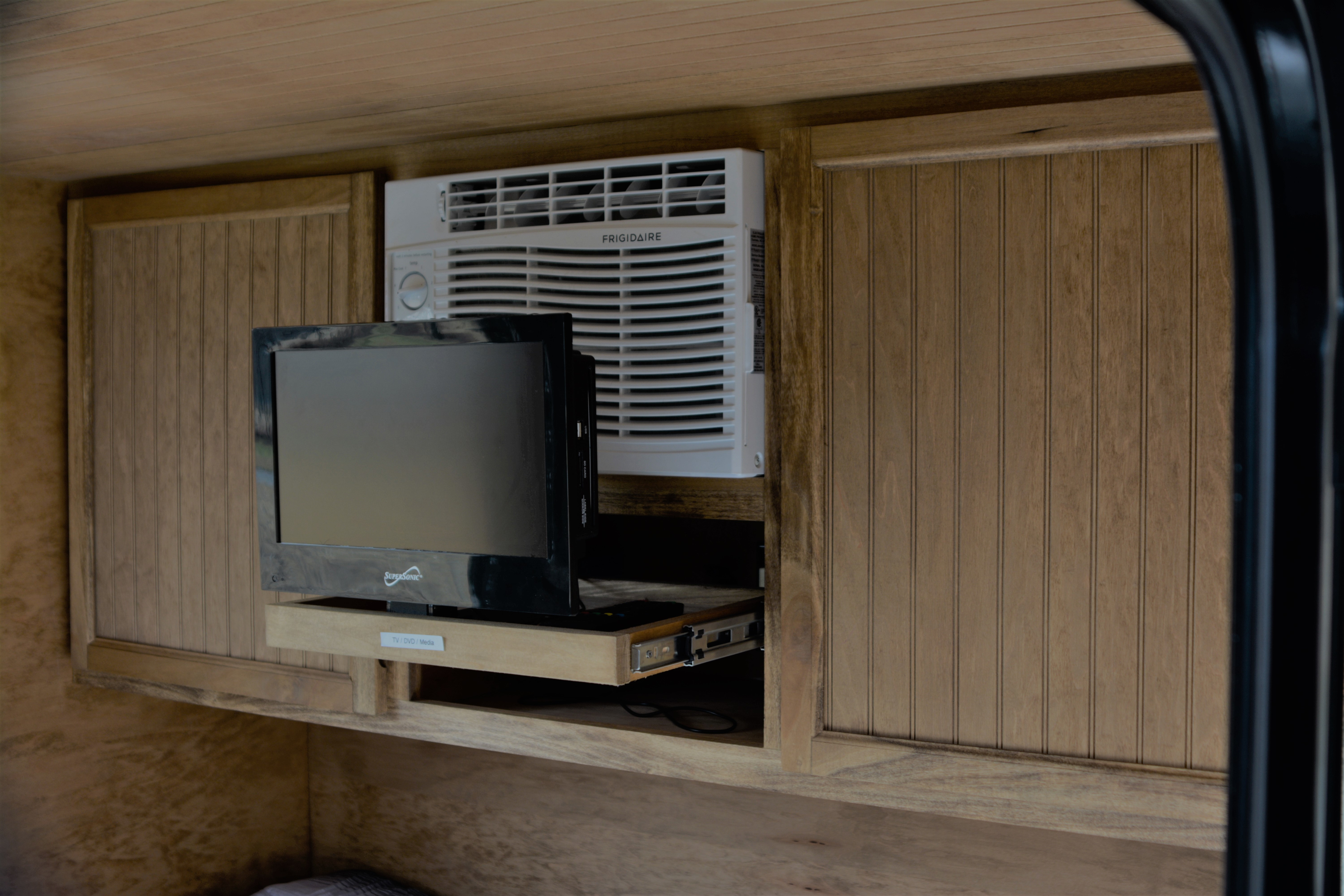 RV rental: Built-in Frigidaire AC unit and a pull-out Supersonic TV/DVD/Media player in a cozy wooden interior.. OK SCHOONERS TEARDROP CS-10 2021