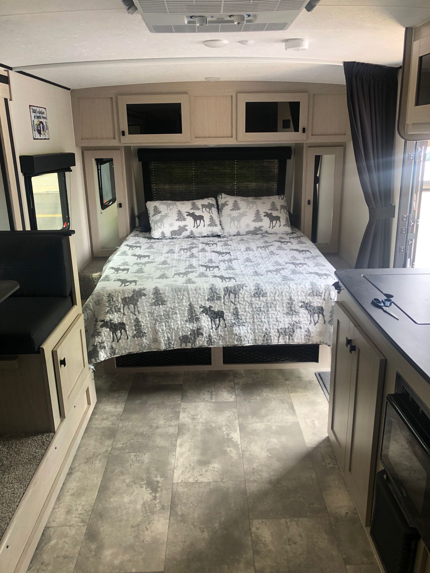 Explore this modern RV rental! Features include a cozy bedroom with moose decor, dinette, & sleek kitchen area.. Coachmen Apex Nano 2023