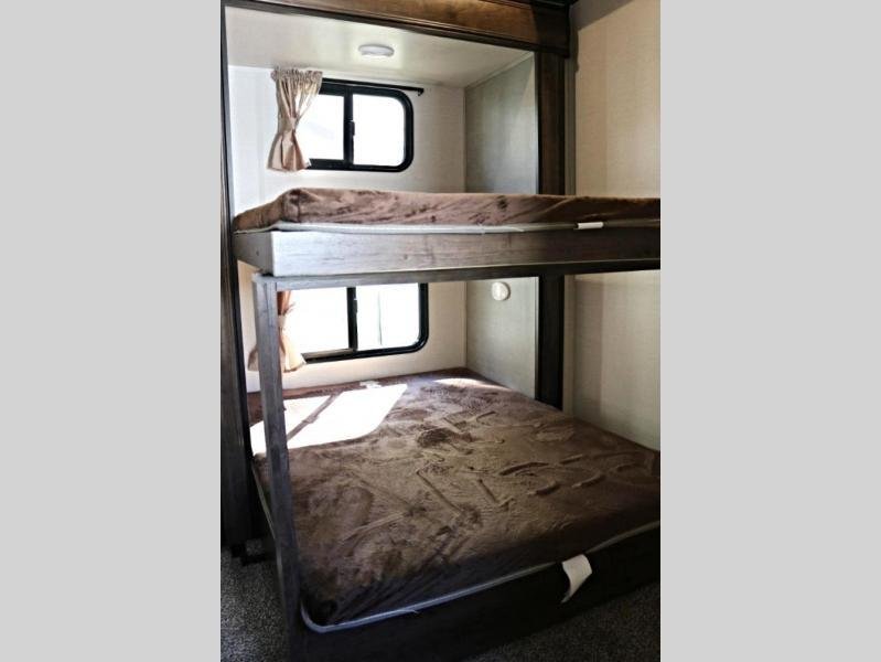 Cozy RV rental bunk beds, each with a window and curtain, offering comfortable sleeping for travelers.. Crossroads RV Volante HP 2018