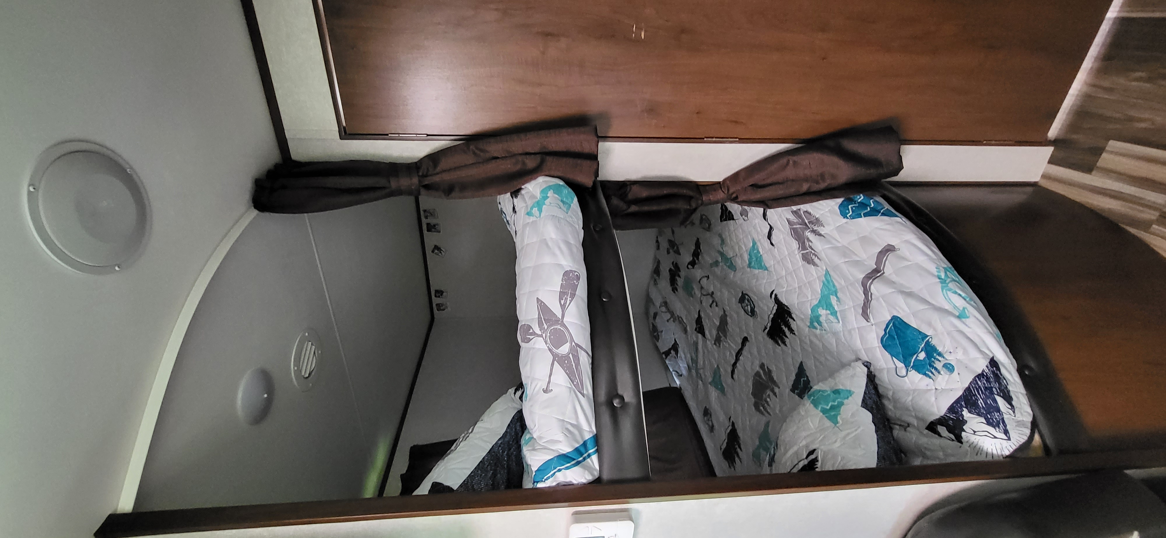 Cozy bunk beds inside an RV rental, featuring themed comforters and built-in speakers. Perfect for compact living.. Jayco Jay Flight 2017