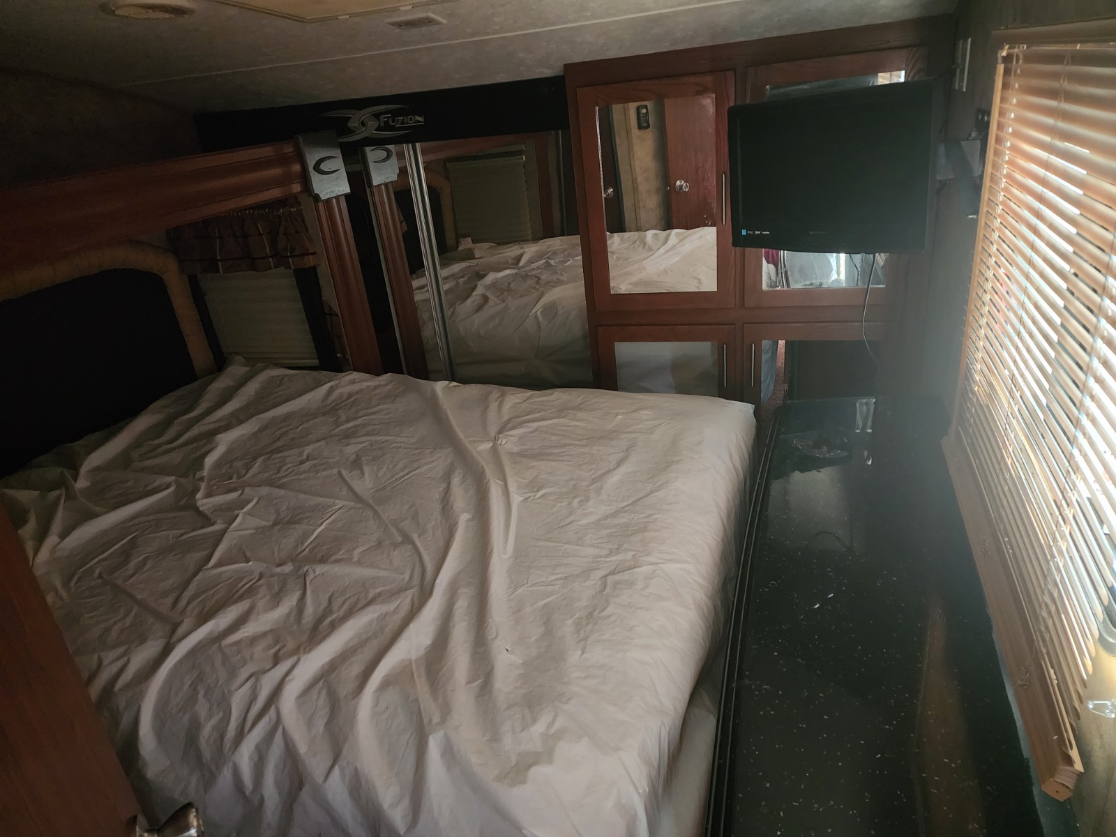 Cozy RV rental bedroom with spacious bed, mirrored closet, and TV for a comfortable journey.. Keystone Fuzion 2010