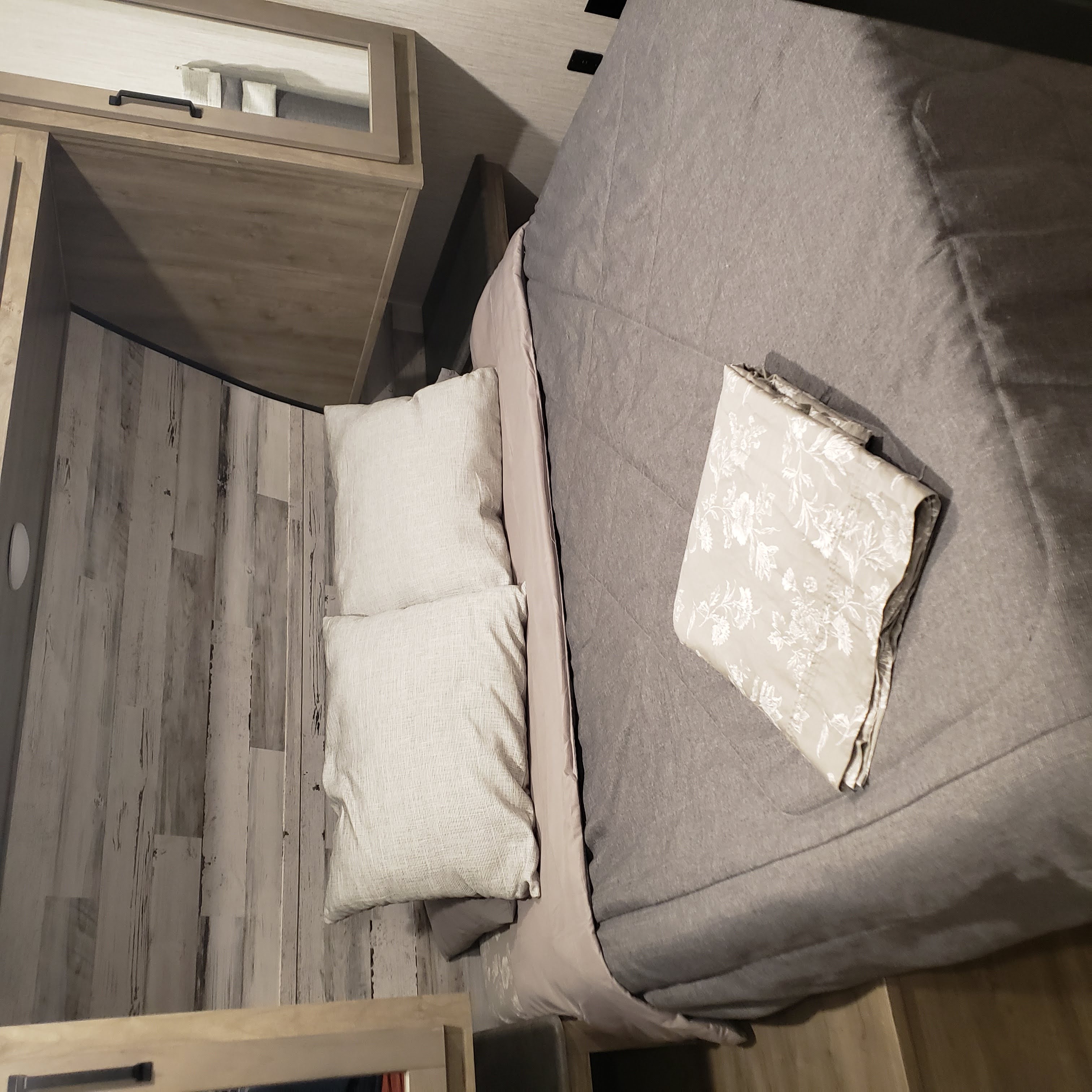 Cozy RV rental bedroom with light wood accents, comfortable bed, and soft gray bedding, ideal for your travels.. Forest River Palomino Puma 2021