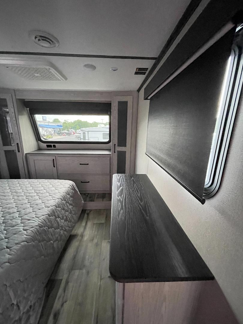 Spacious and modern RV rental bedroom with comfortable bed, ample storage, and window views. Perfect for your next adventure.. Keystone RV Montana High Country 2022