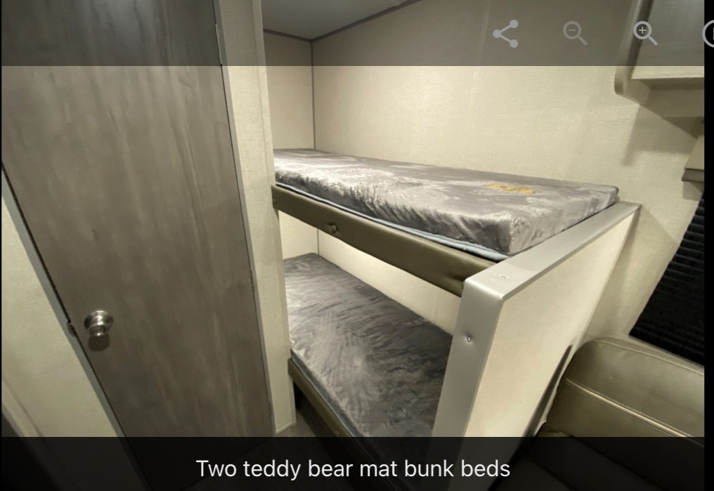 RV rental features: two bunk beds with grey mattresses, providing compact sleeping in a cozy space.. Forest River Aurora Lite 16BHX 2023