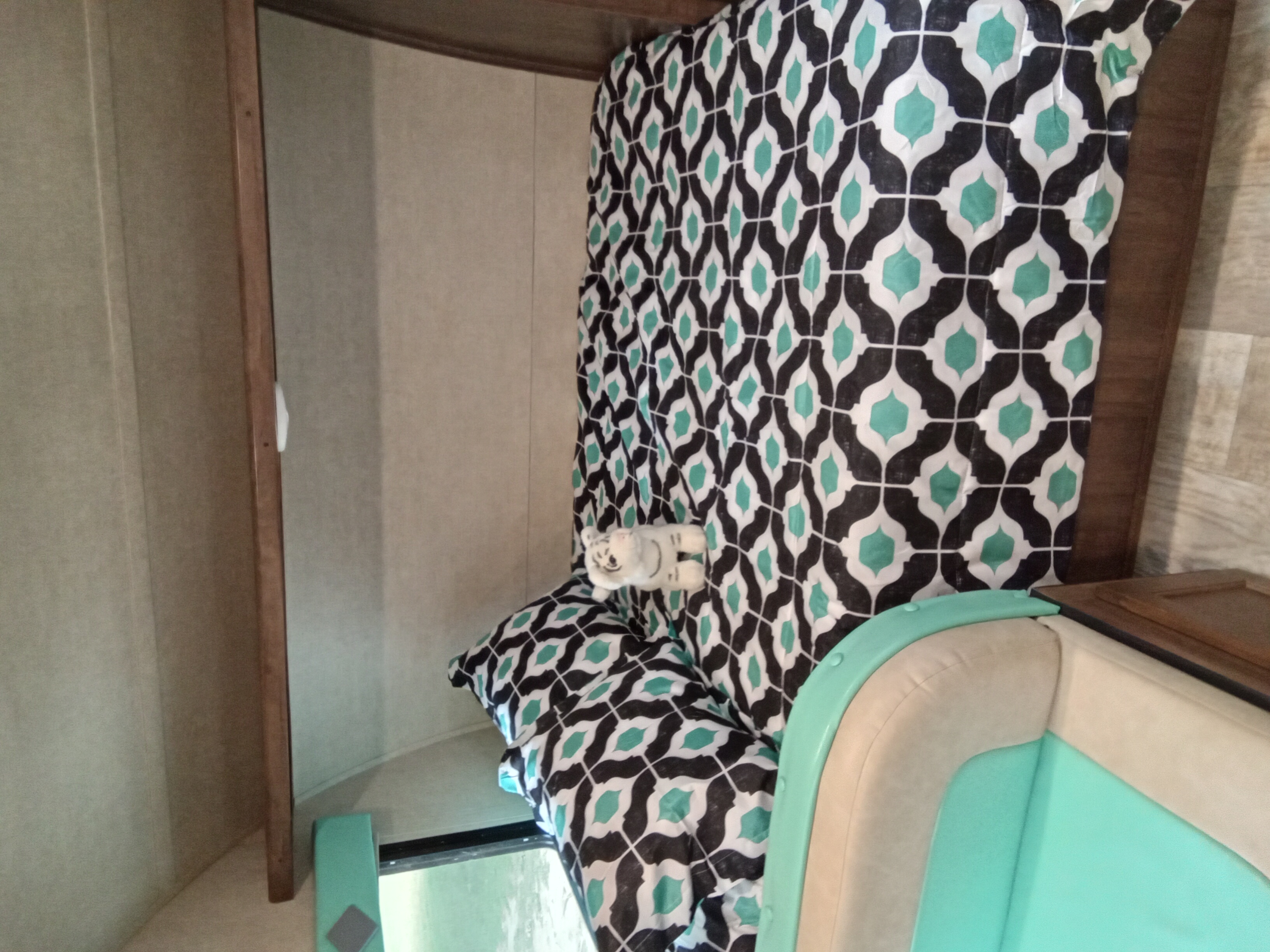 RV rental interior: Patterned bedding with a plush toy and aqua/beige seating offer a cozy, ready-for-travel space.. Gulf Stream Capri 2019
