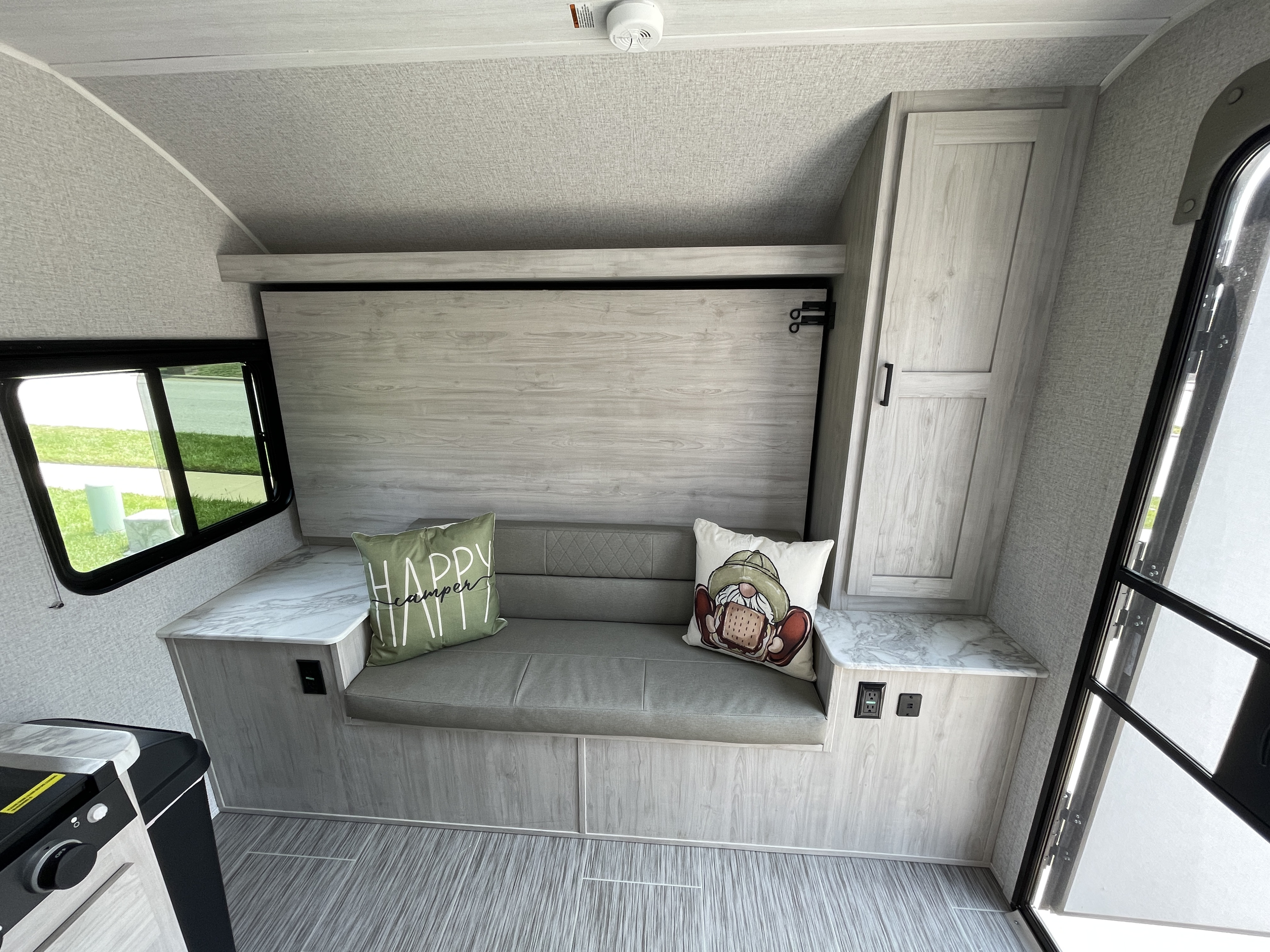 Modern RV rental interior with compact seating, window view, and kitchen. Ready for your adventures.. East to West Silver Lake LE 2023