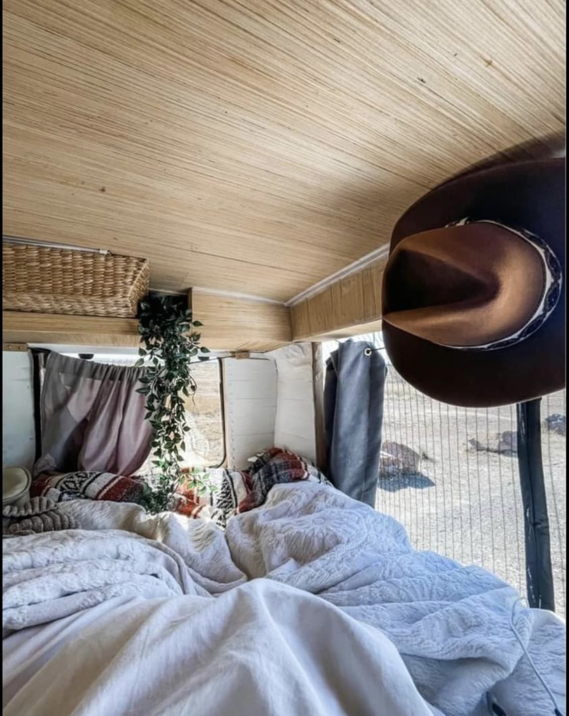 Cozy RV rental interior: soft bed, wood ceiling, and a hat. Perfect for tranquil adventures on the road.. Gmc Savanna C1500 2005