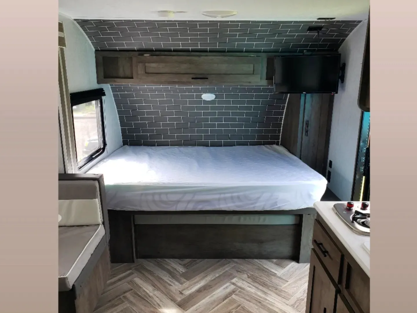 Modern RV rental interior: features a comfy bed, TV, window, dinette & compact kitchenette area.. Forest River Salem FSX 2022
