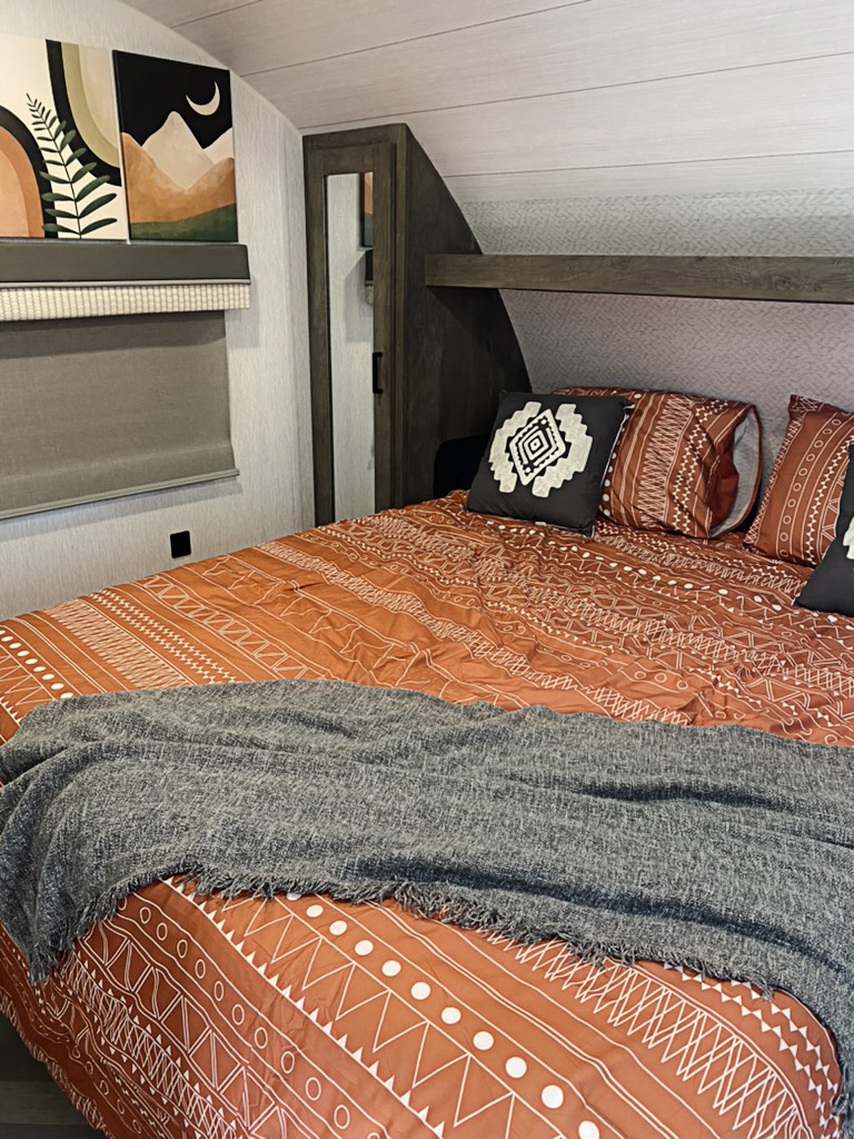 The main bedroom is cozy with lots of storage.. Forest River Wildwood X-Lite 2022