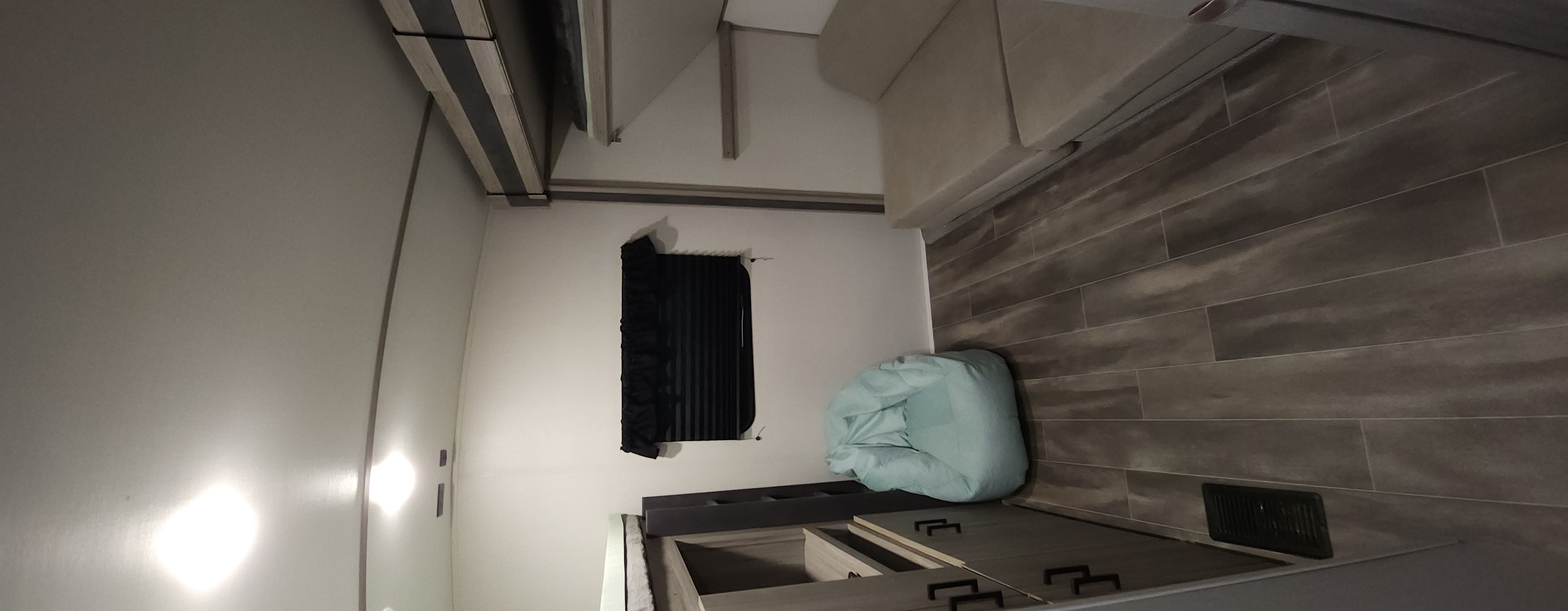 Bright rv rental interior with plank flooring, modern cabinets, window with dark blinds, and light-colored sofa.. Keystone RV Passport GT 2022