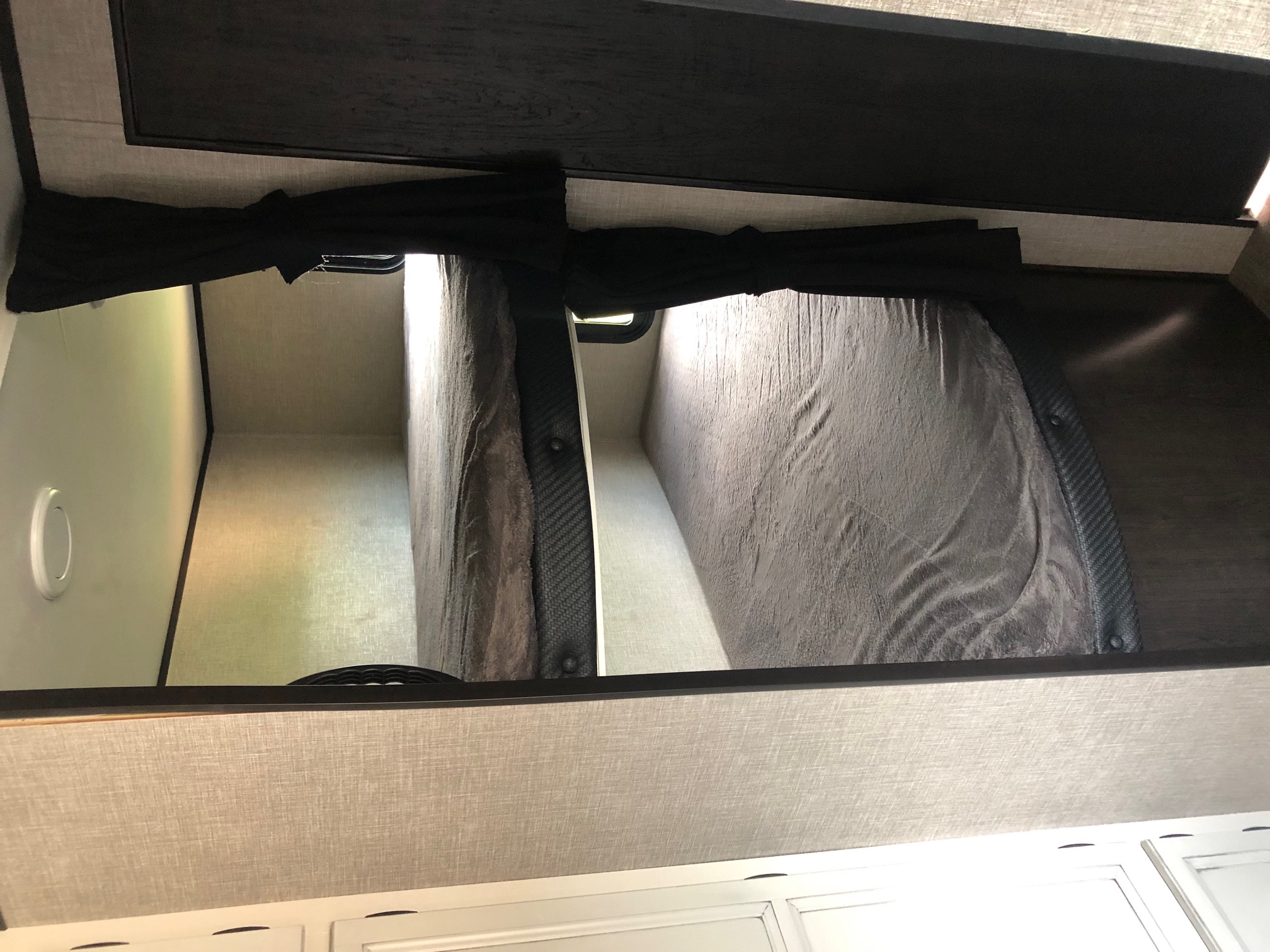 Inside an RV rental: Stacked bunk beds with gray bedding provide a compact sleeping area for your adventure.. Jayco Jay Flight 2022