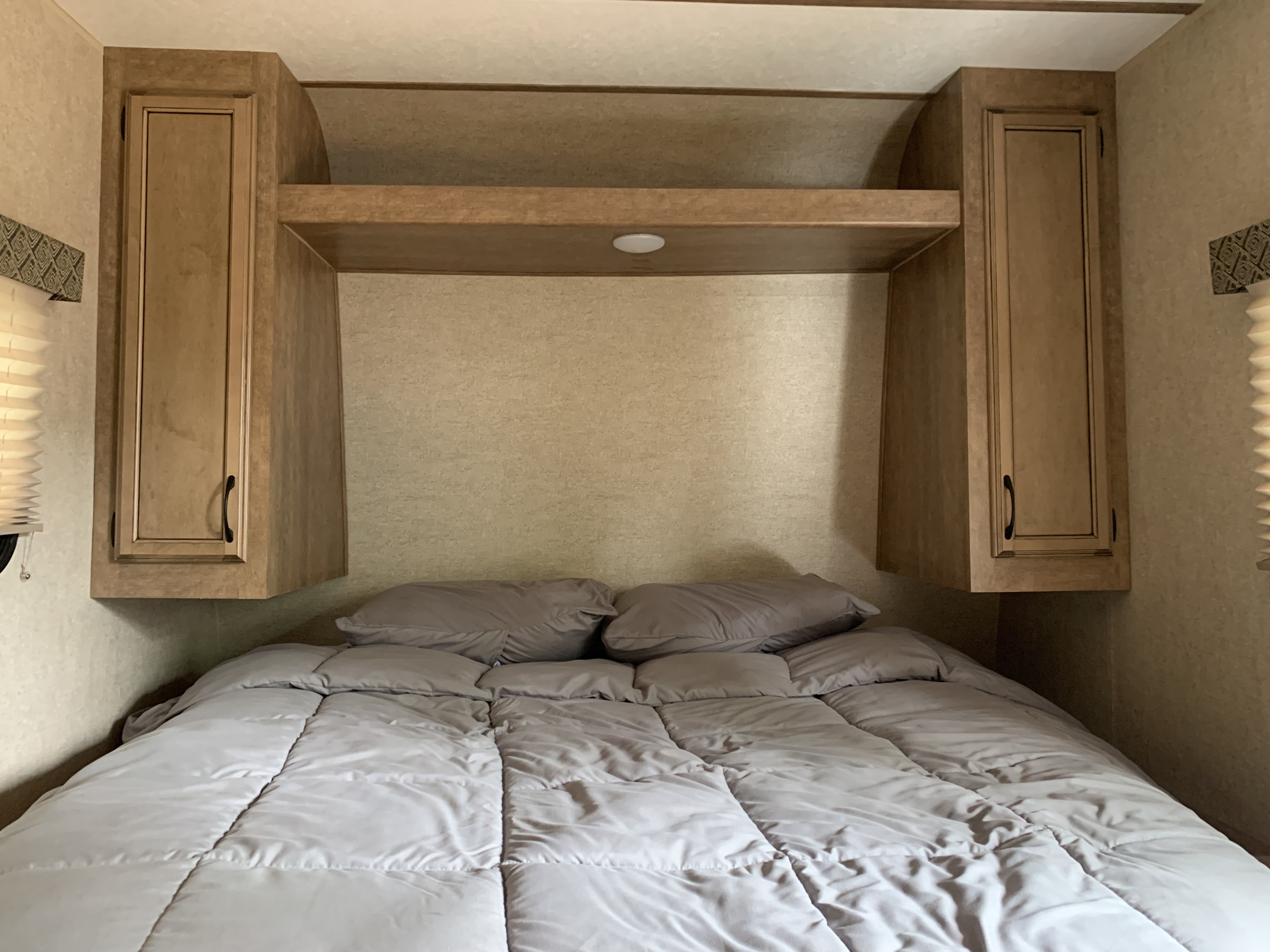 Cozy RV rental bedroom with overhead storage, a light, and a comfy bed.. Starcraft Launch Outfitter Extreme 2018