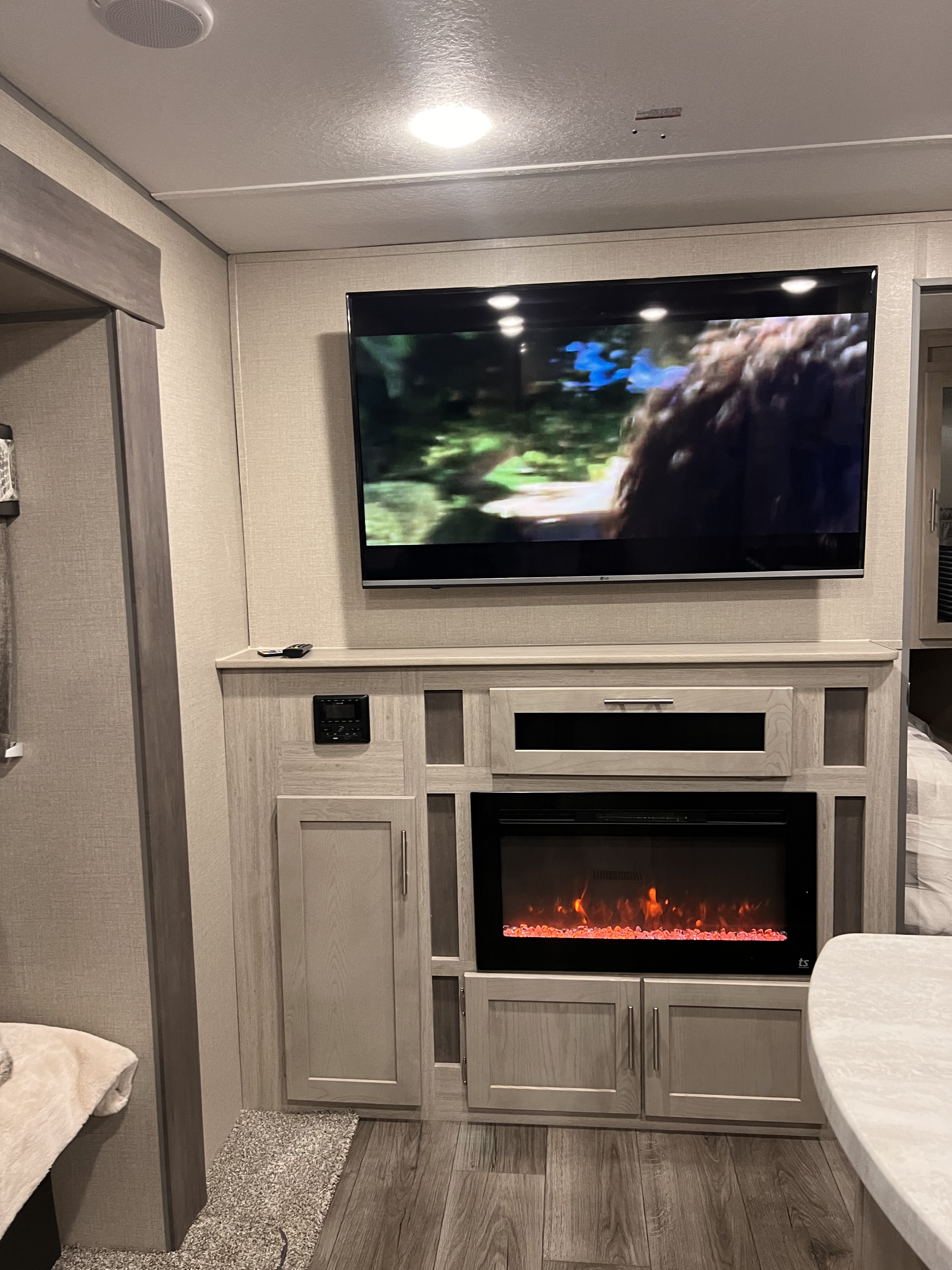 Modern RV rental interior featuring a TV, electric fireplace, and integrated entertainment center, offering a cozy ambiance.. Coachmen Catalina Legacy Edition 2022