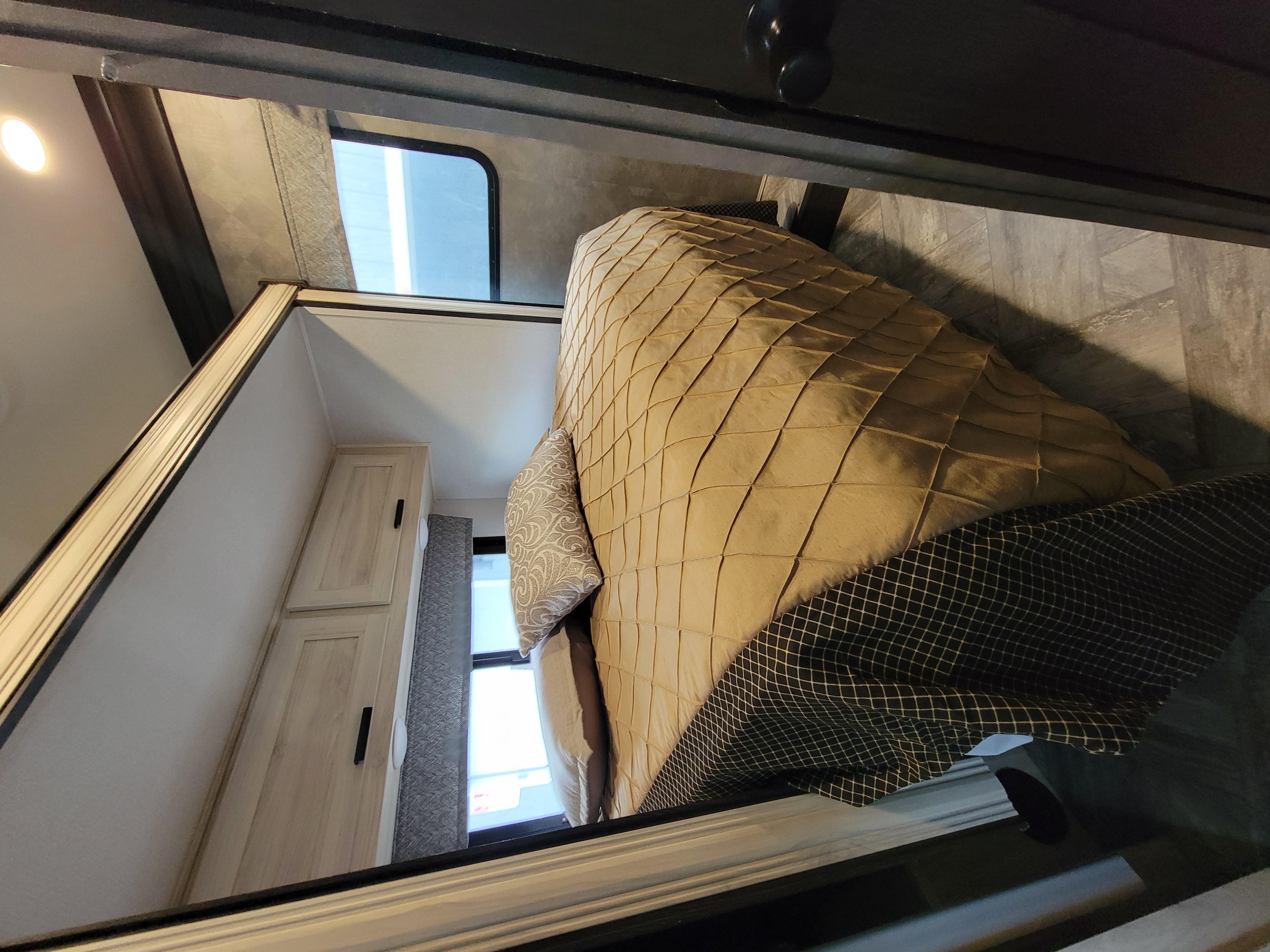 An inviting RV rental bedroom featuring a quilted bed, large window, and light-toned cabinets, ready for your travel.. Forester FRC2551DSLEF 2022