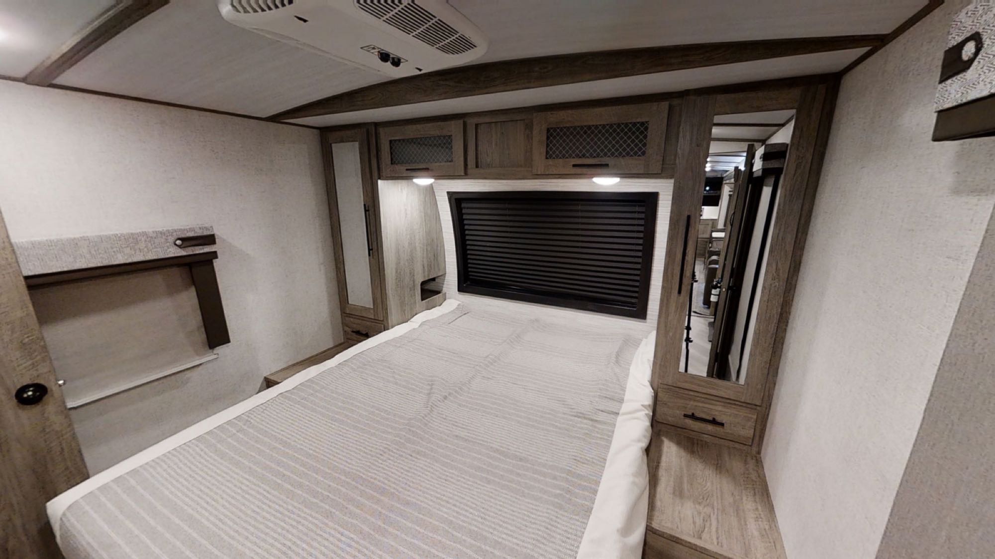 Explore a compact RV rental bedroom, featuring a comfortable bed, overhead storage, and AC for your travels.. Forest River Wildwood Heritage Glen 2021