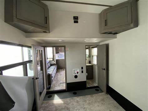 Spacious, modern RV rental interior featuring overhead cabinets, large windows, living area, and laundry hookup.. Keystone Carbon 2021
