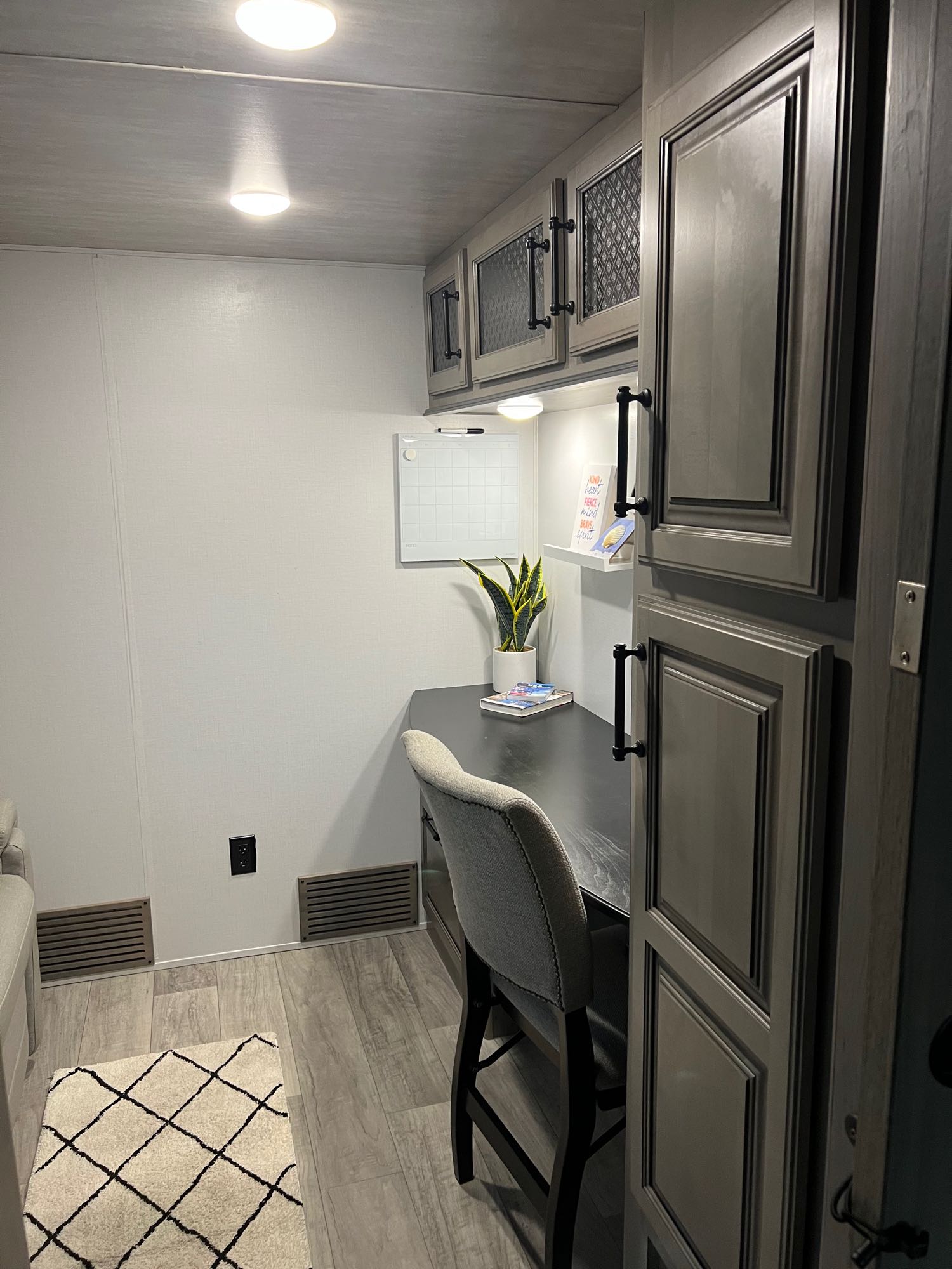 Modern RV rental workspace featuring a built-in desk, comfy chair, and overhead cabinets for a functional travel office.. Keystone RV Montana 2022