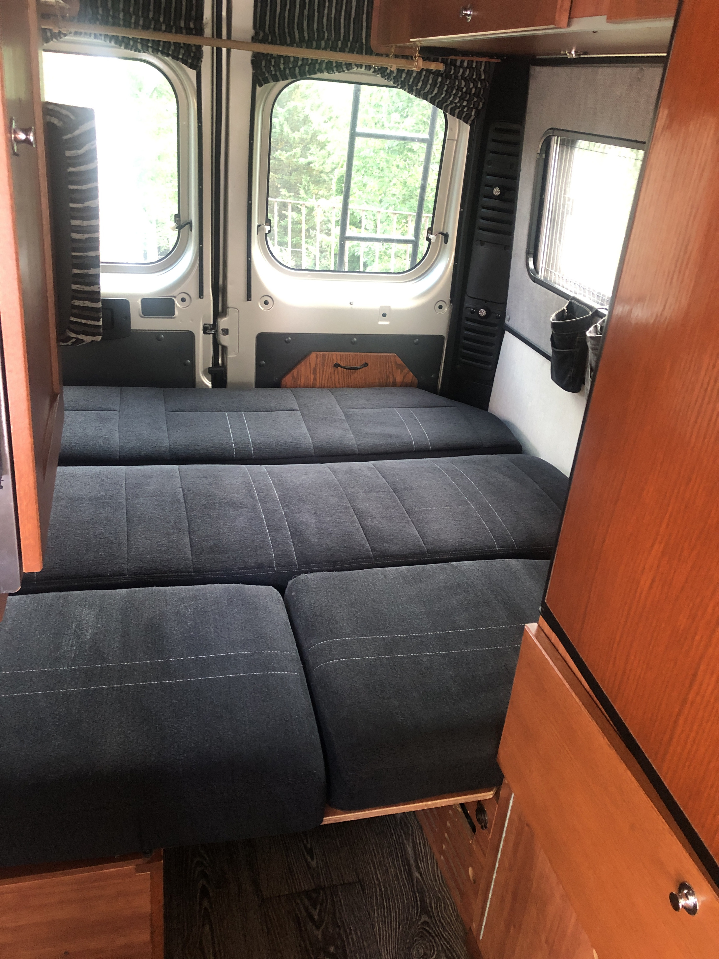 This shows the seat folded down to form the bad. It is designed for people to sleep crossways, with head and feet to the sides of the RV.. Roadtrek Roadtrek Class B 2019