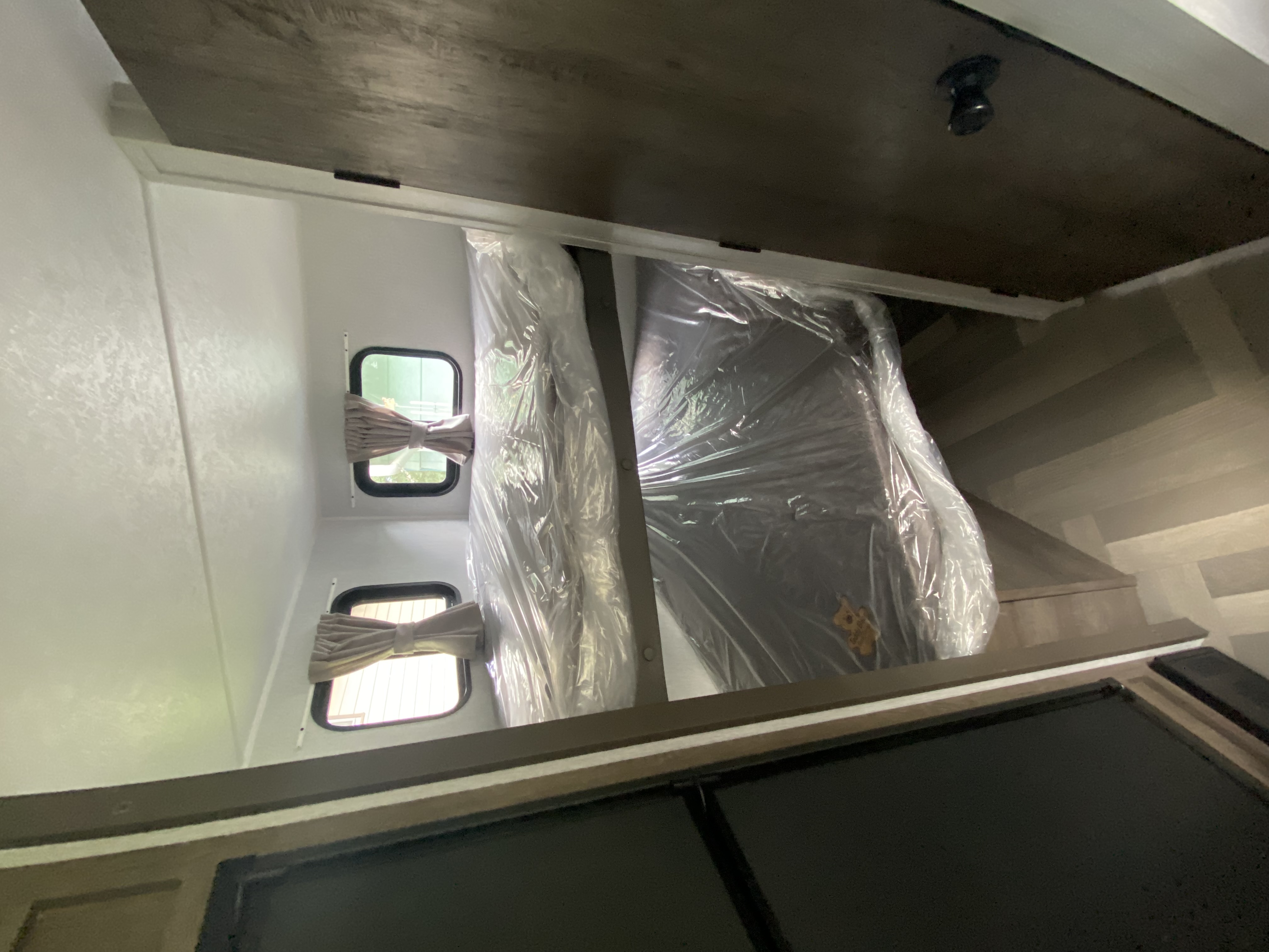 RV rental interior: Two bunk beds, plastic-wrapped, with windows and stairs leading to the sleeping area.. Forest River Salem FSX 2022