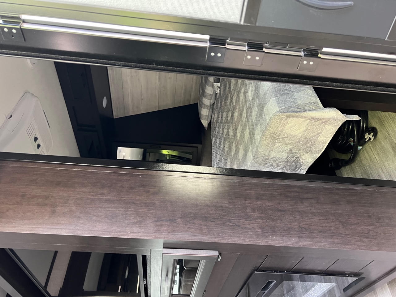 Inside this RV rental: an upper bunk with a cozy quilt, AC unit, and stored RV gear.. Jayco Jay Flight 2022