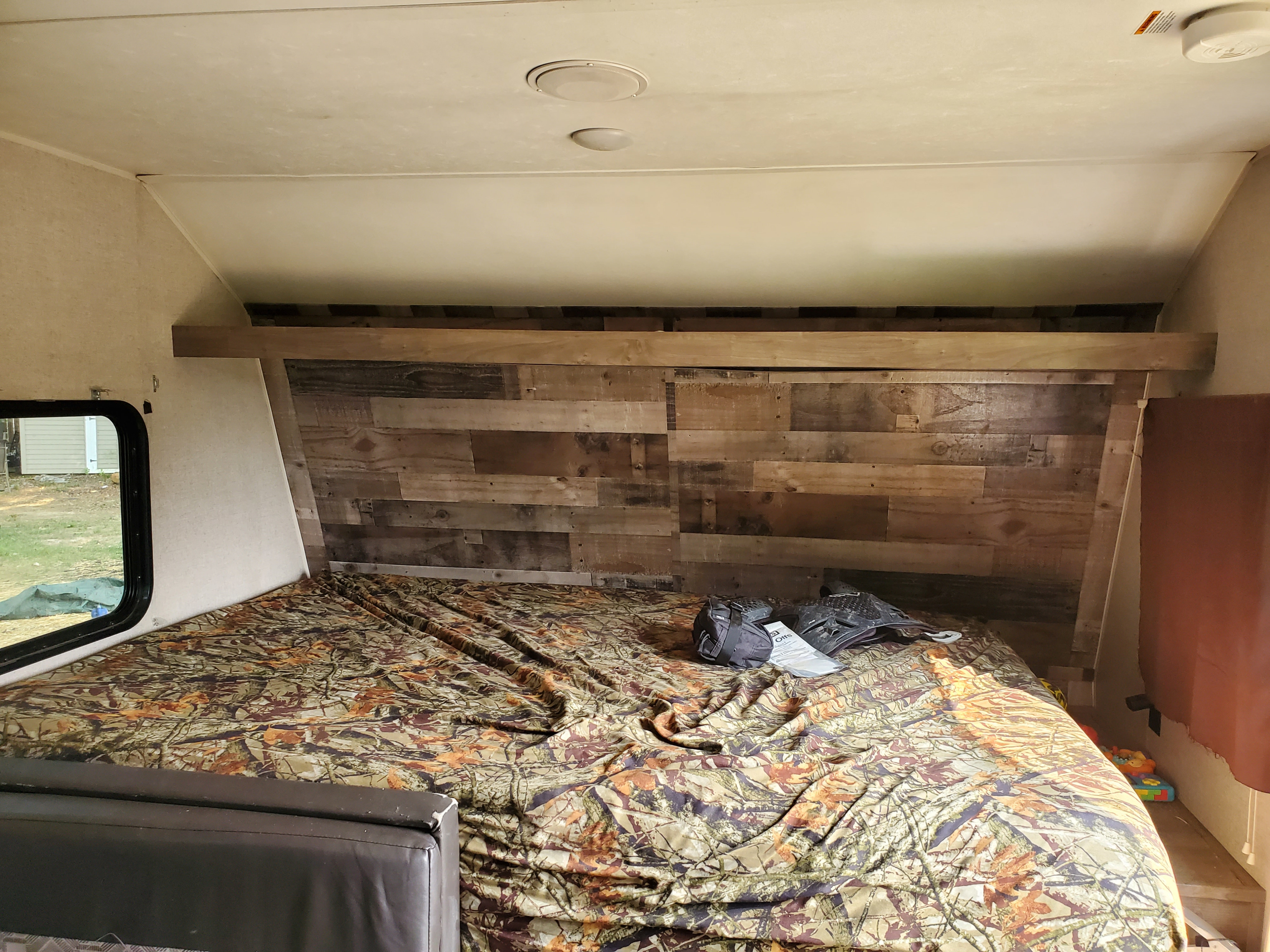 Rv rental over-cab bunk features a camouflage comforter & rustic wooden headboard.. Aspen Trail Aspen Trail Trailer 2019