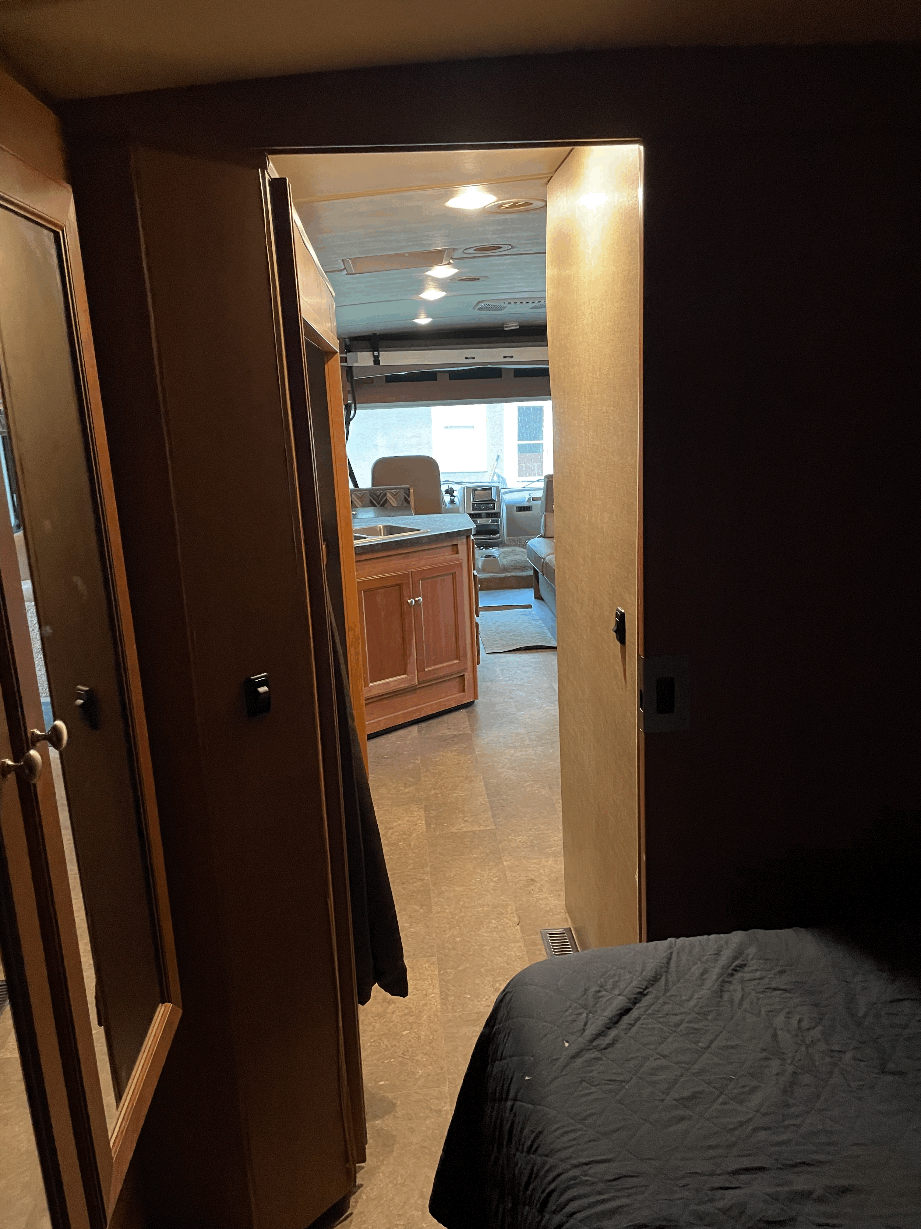 Inside an RV rental: a view from the bedroom past the kitchen to the cockpit, highlighting the interior layout.. Winnebago Vista 2018