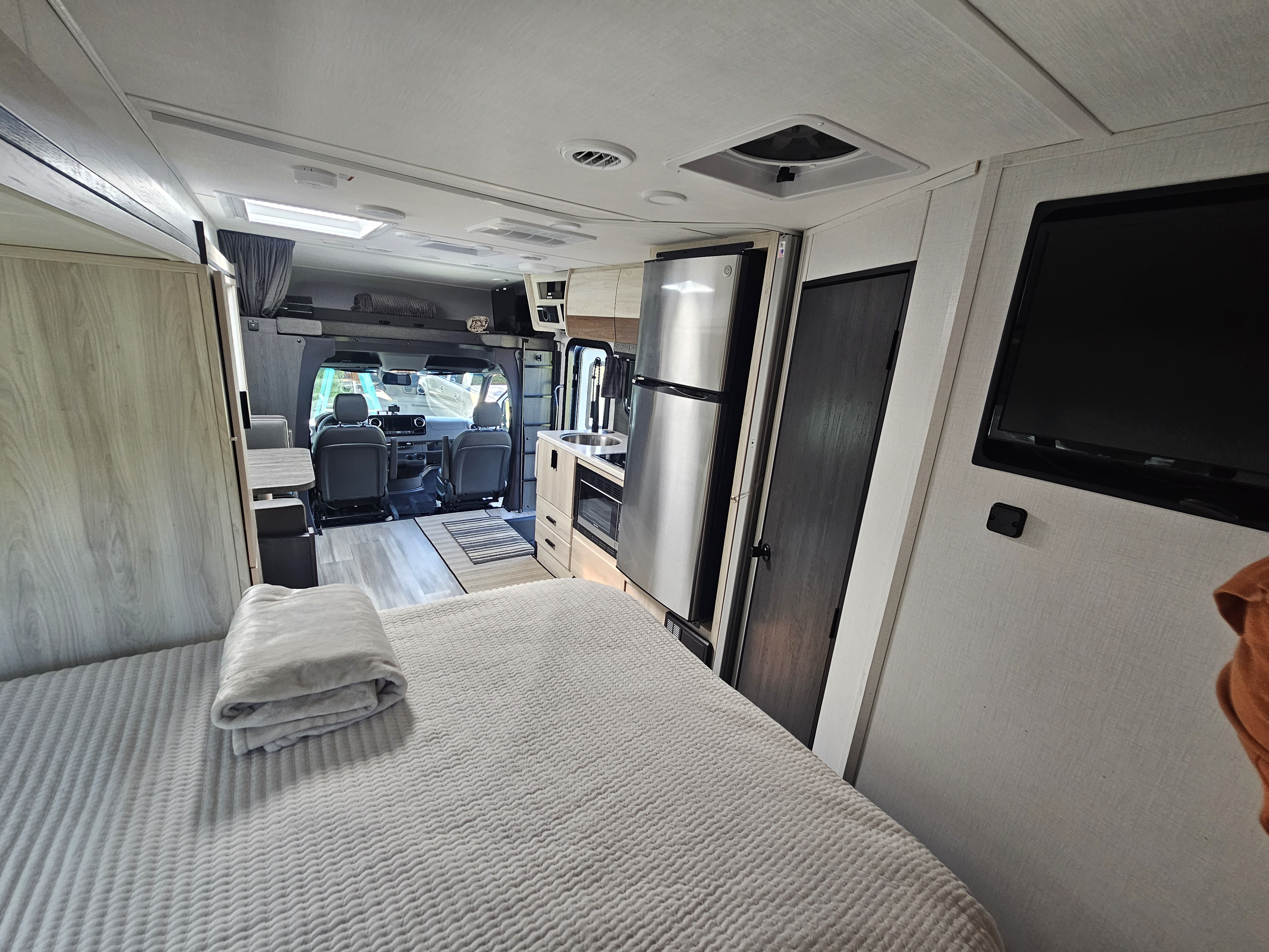 Inside a modern RV rental: bedroom, full kitchen, and front cabin visible. Perfect for road trips.. Forest River Forester 2401B 2023