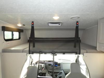 Spacious RV rental interior featuring an overhead sleeping bunk above the cockpit and two side bunks, perfect for family adventures.. Coachmen Freelander 29KB 2023