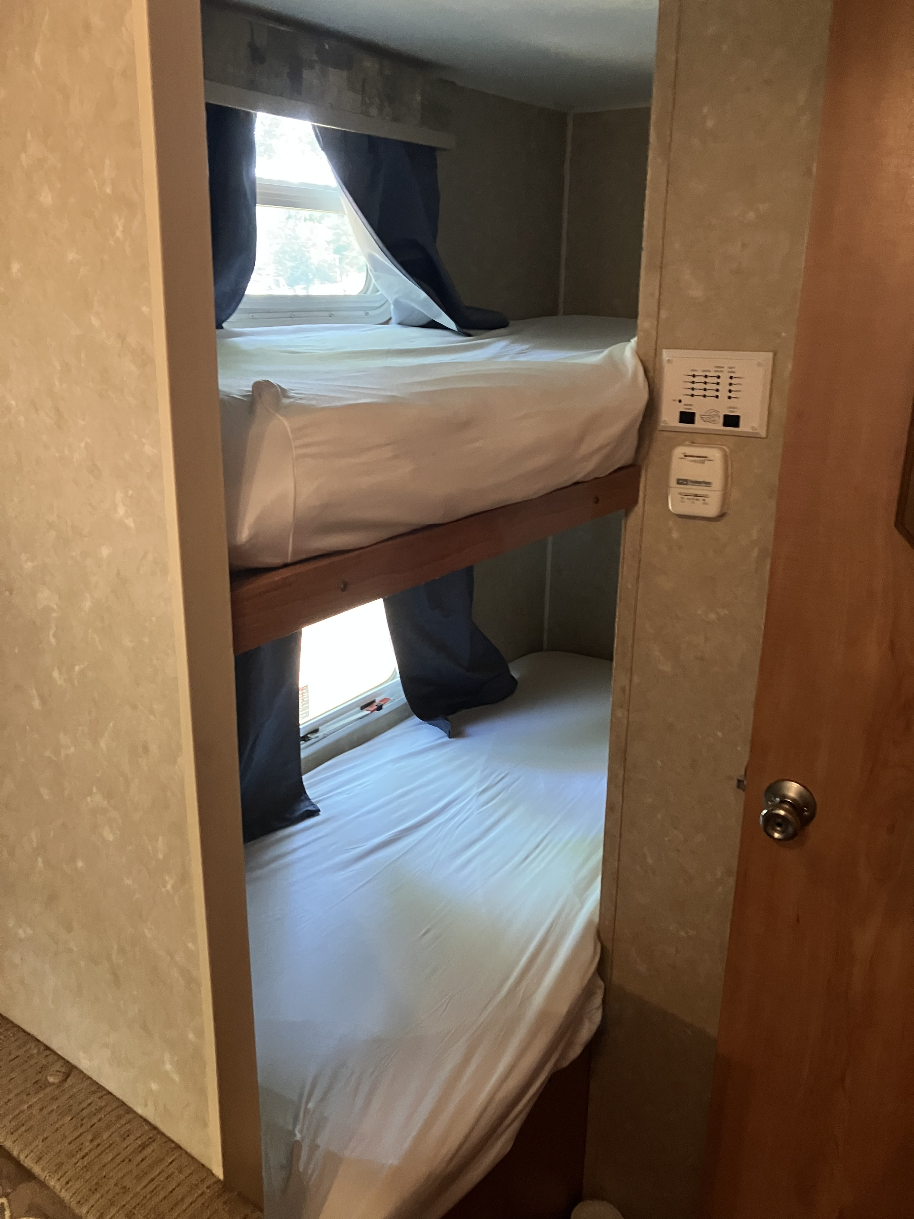 RV rental interior: two bunk beds with windows and controls, offering a cozy sleeping area.. Gulf Stream Ameri-Lite 25 BS 2008